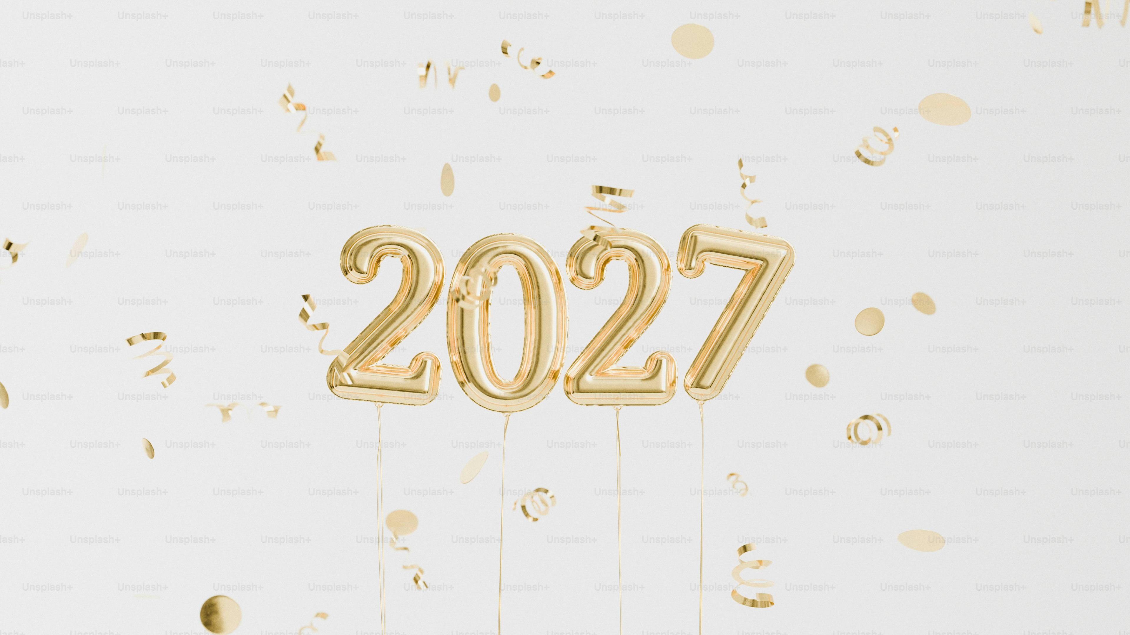 Gold foil balloons forming the number 2027 with falling confetti on white