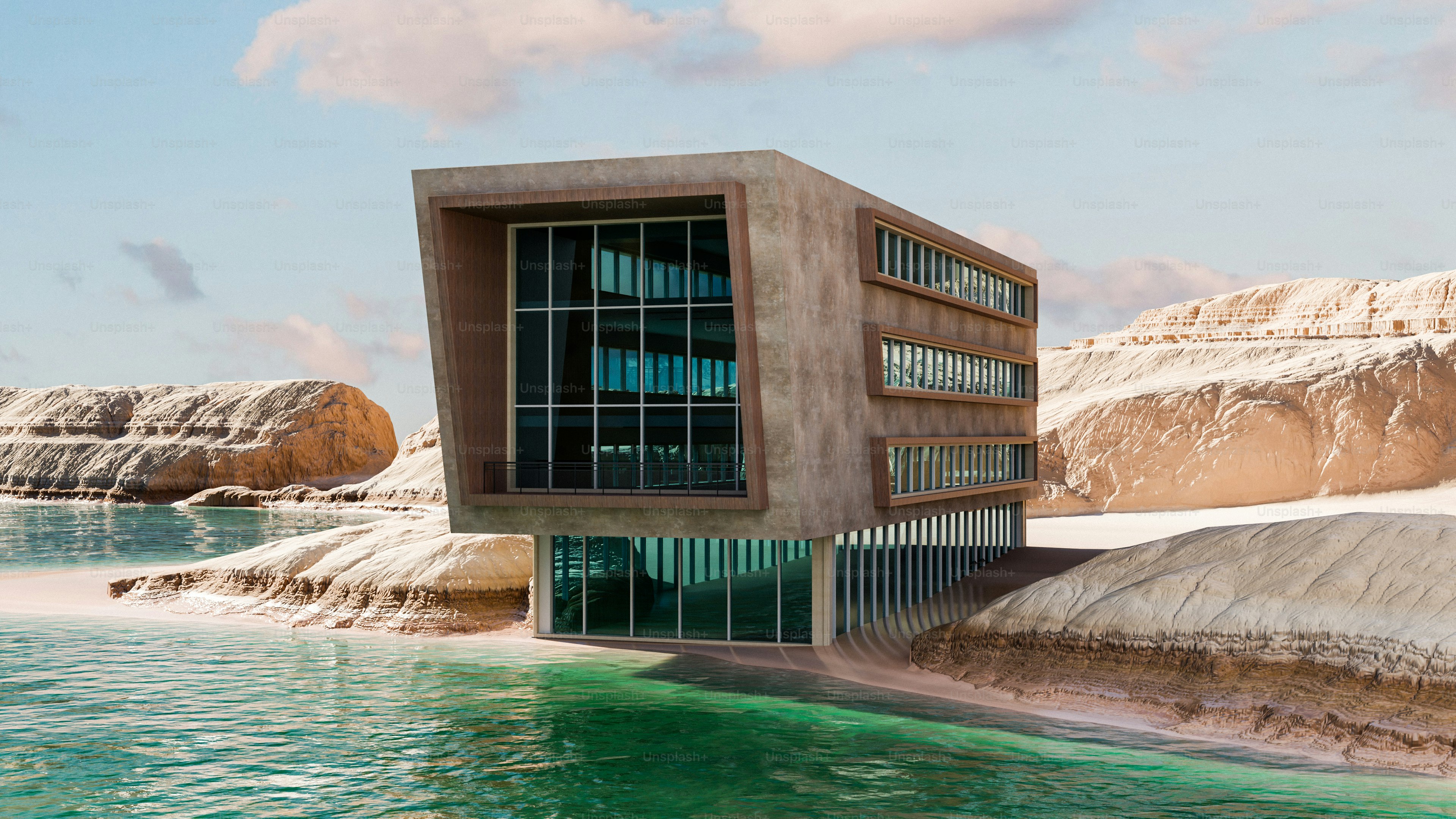 A modern concrete building with large glass windows on a rocky desert shoreline