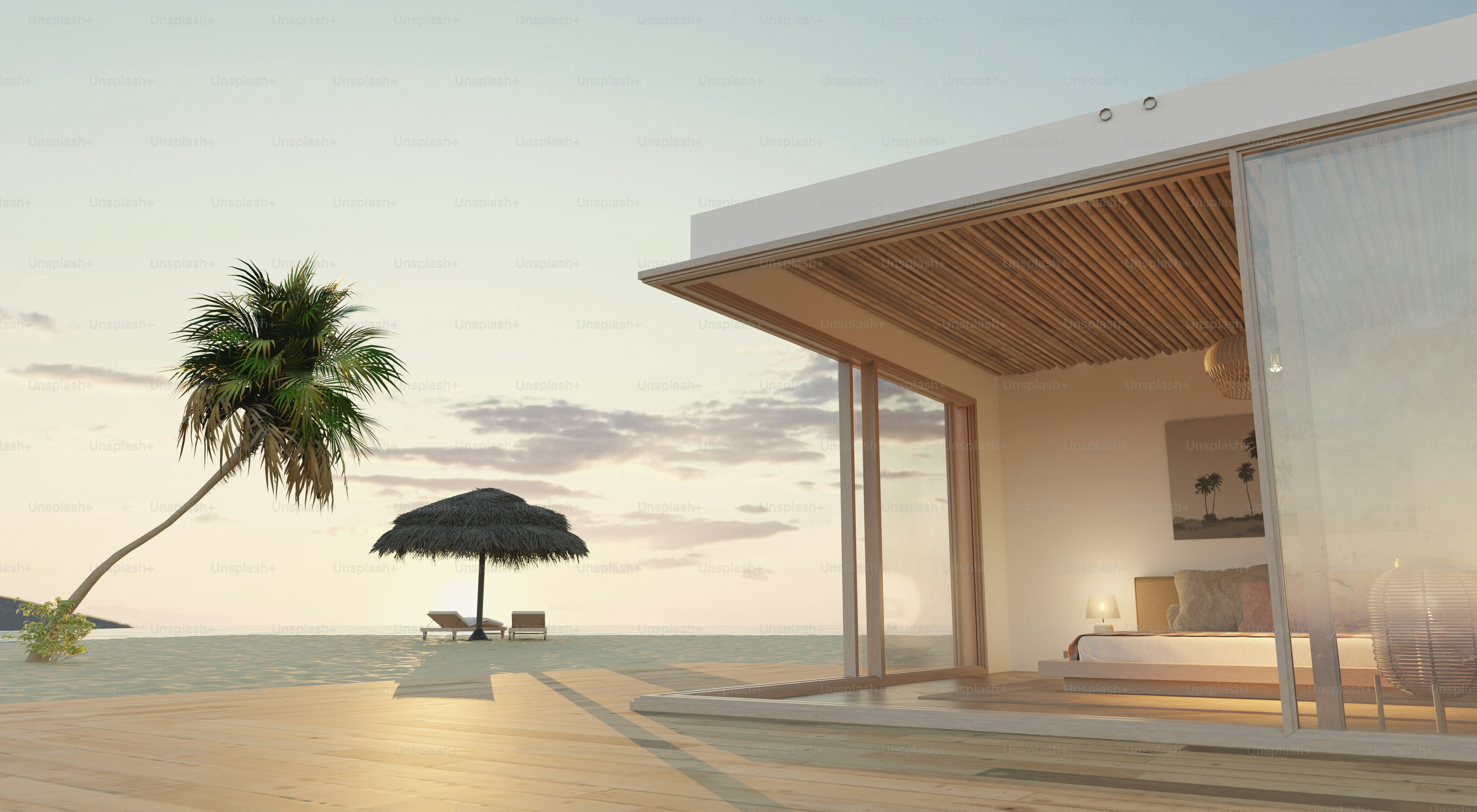 A modern beach villa with a bedroom opening onto a wooden deck at low sun