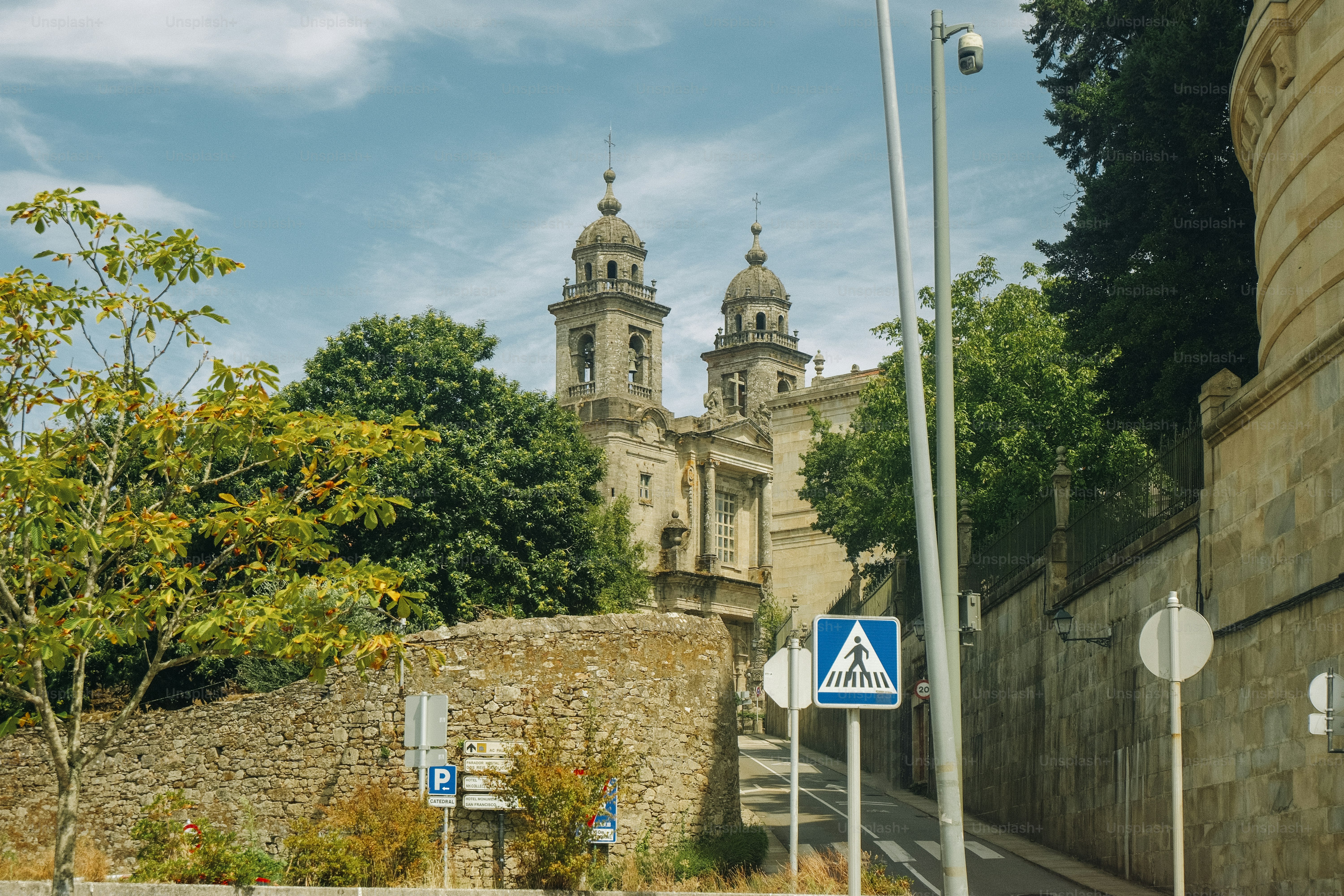 Kathedraltürme, die über Steinmauern und Bäume in Santiago de Compostela ragen