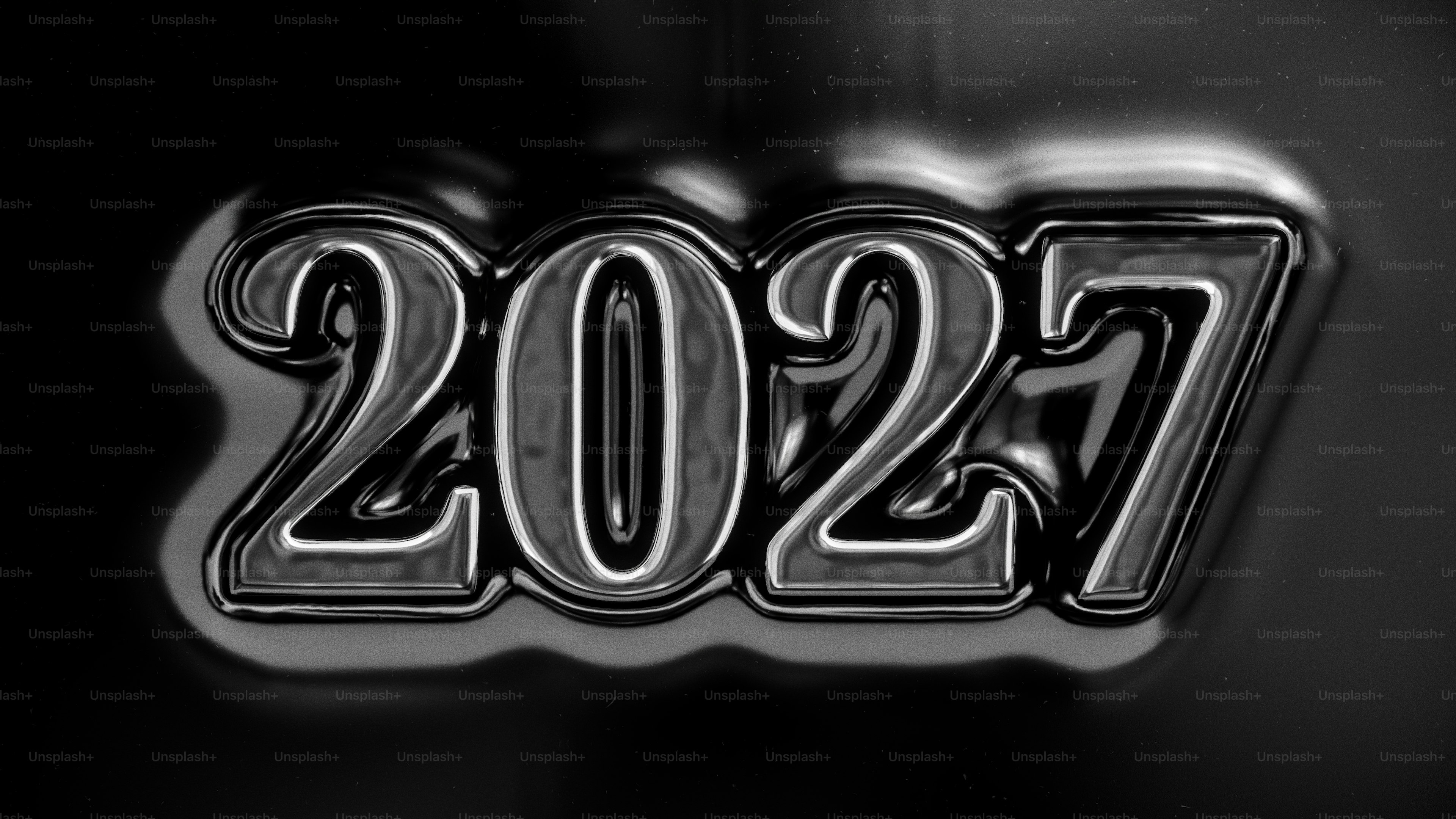 The number 2027 in glossy black liquid metal against a dark background
