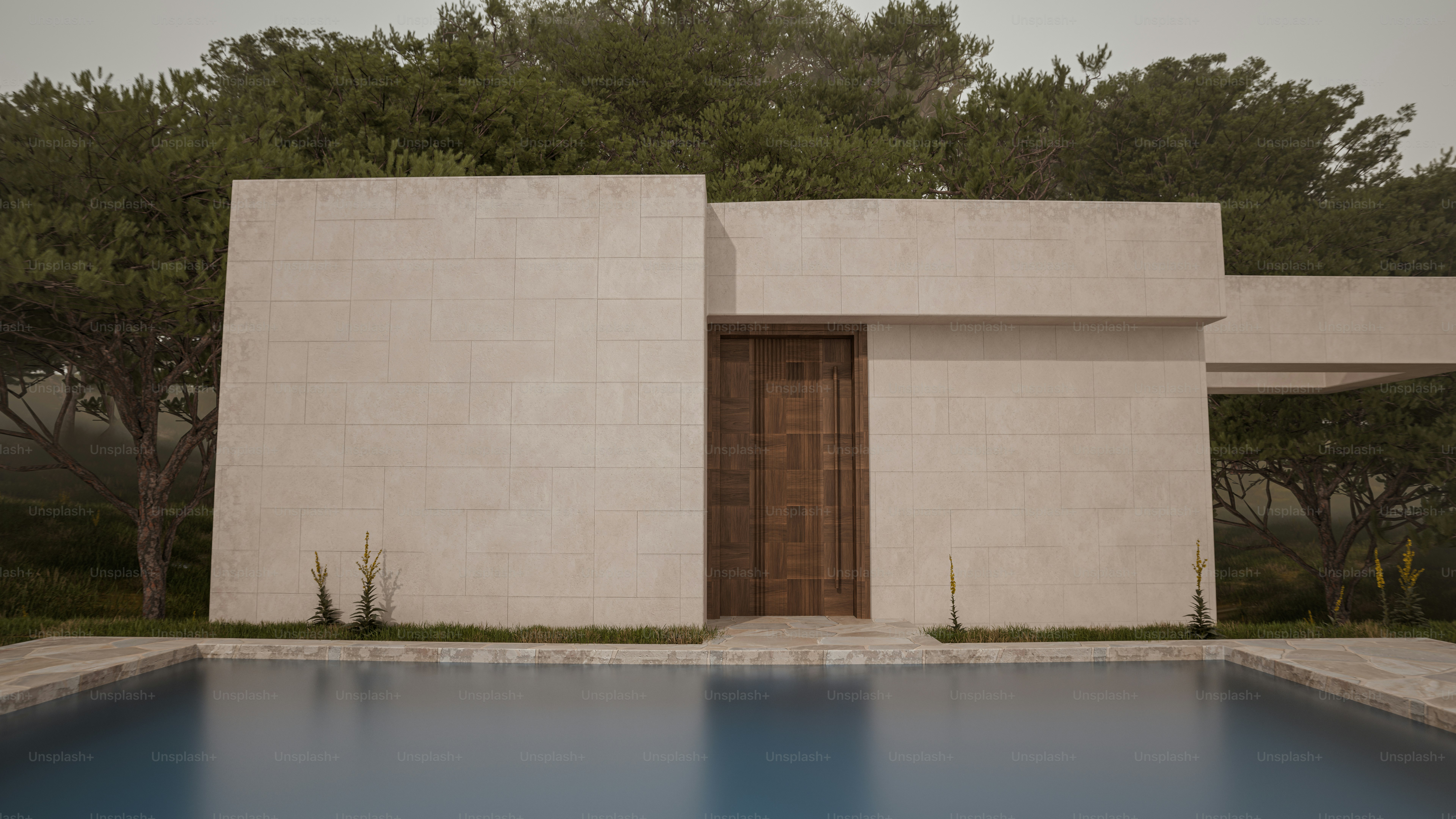 A modern stone house with a wooden door beside a swimming pool