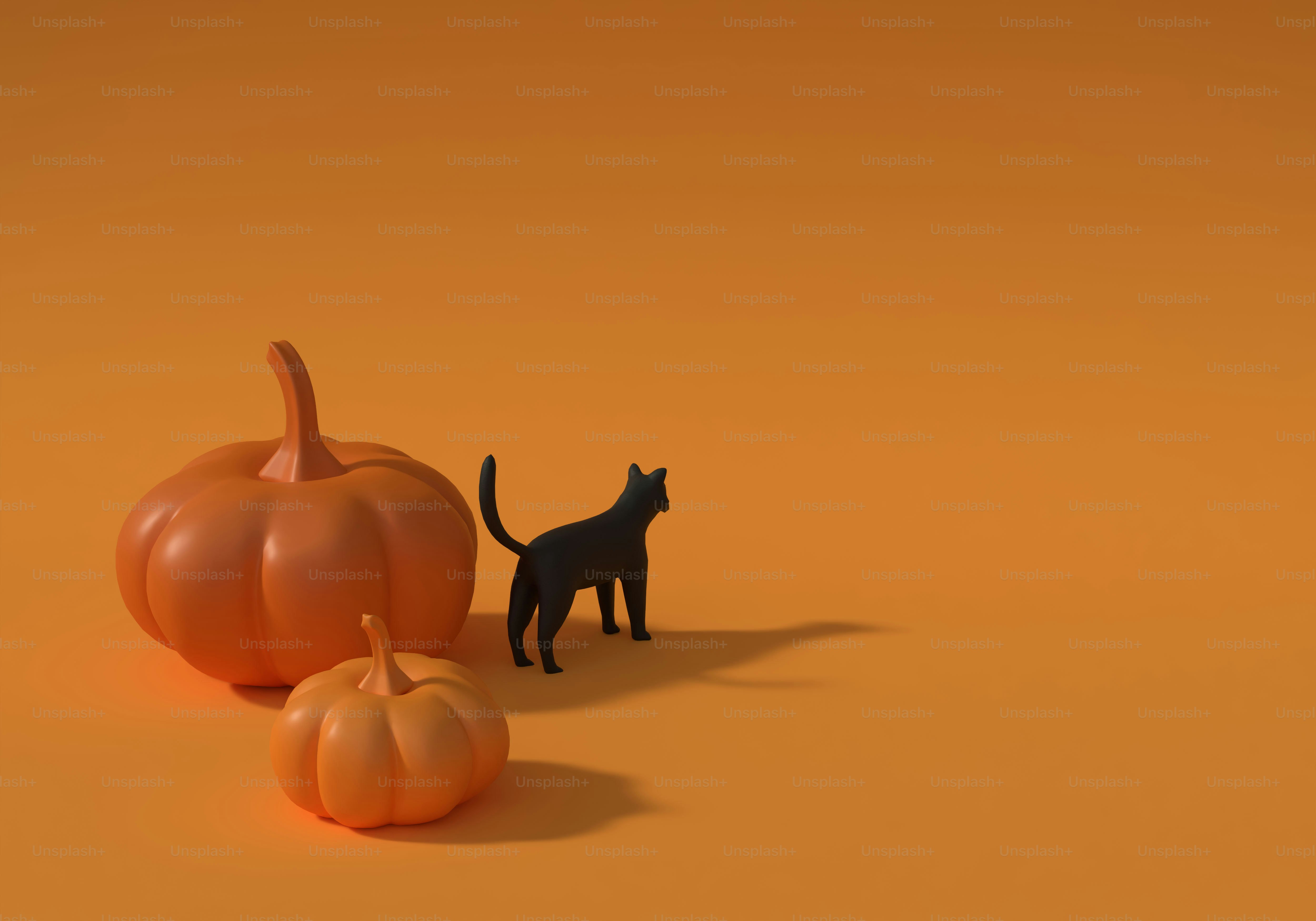Two orange pumpkins and a black cat figurine on an orange surface