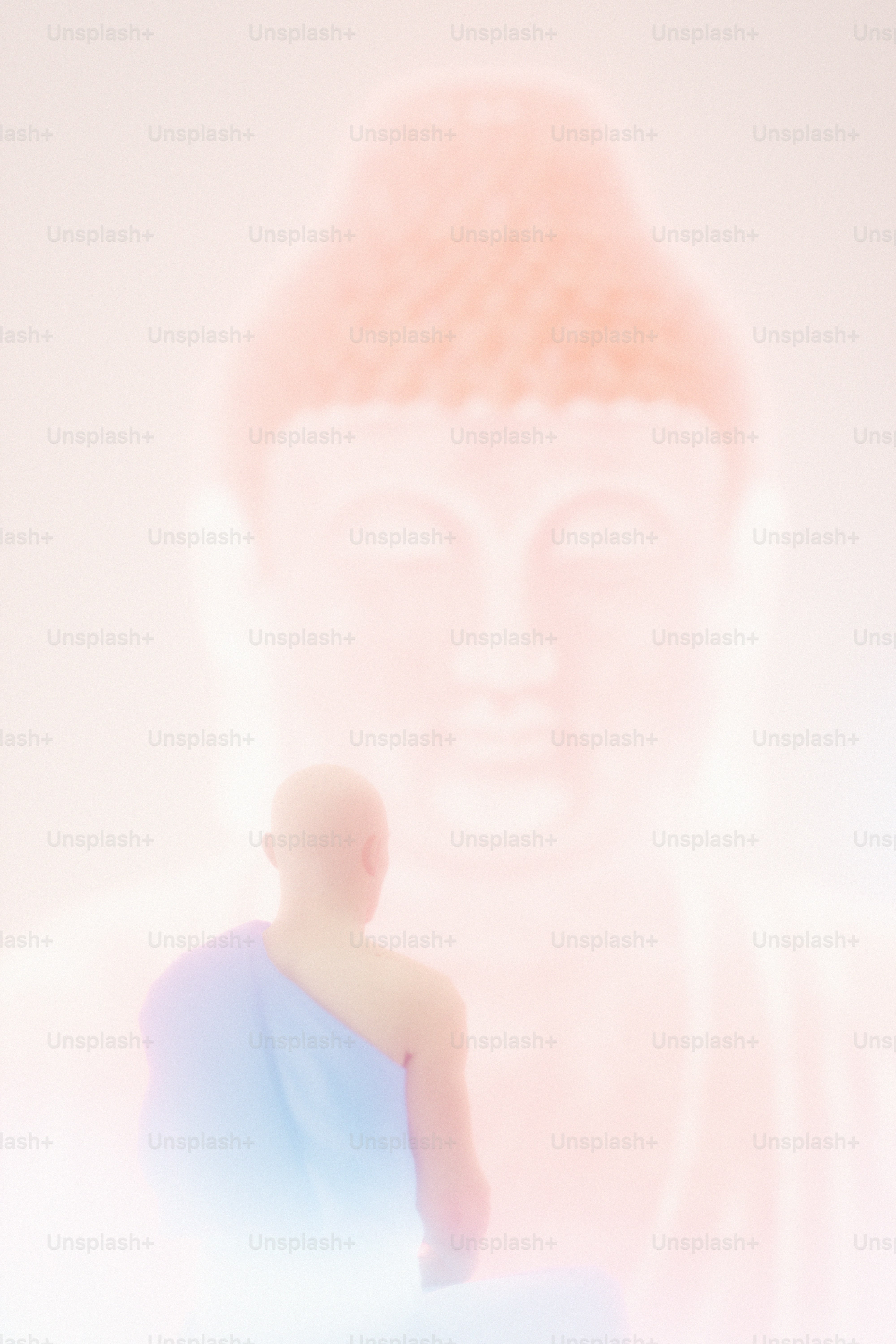 A person in a blue robe facing a large glowing Buddha statue