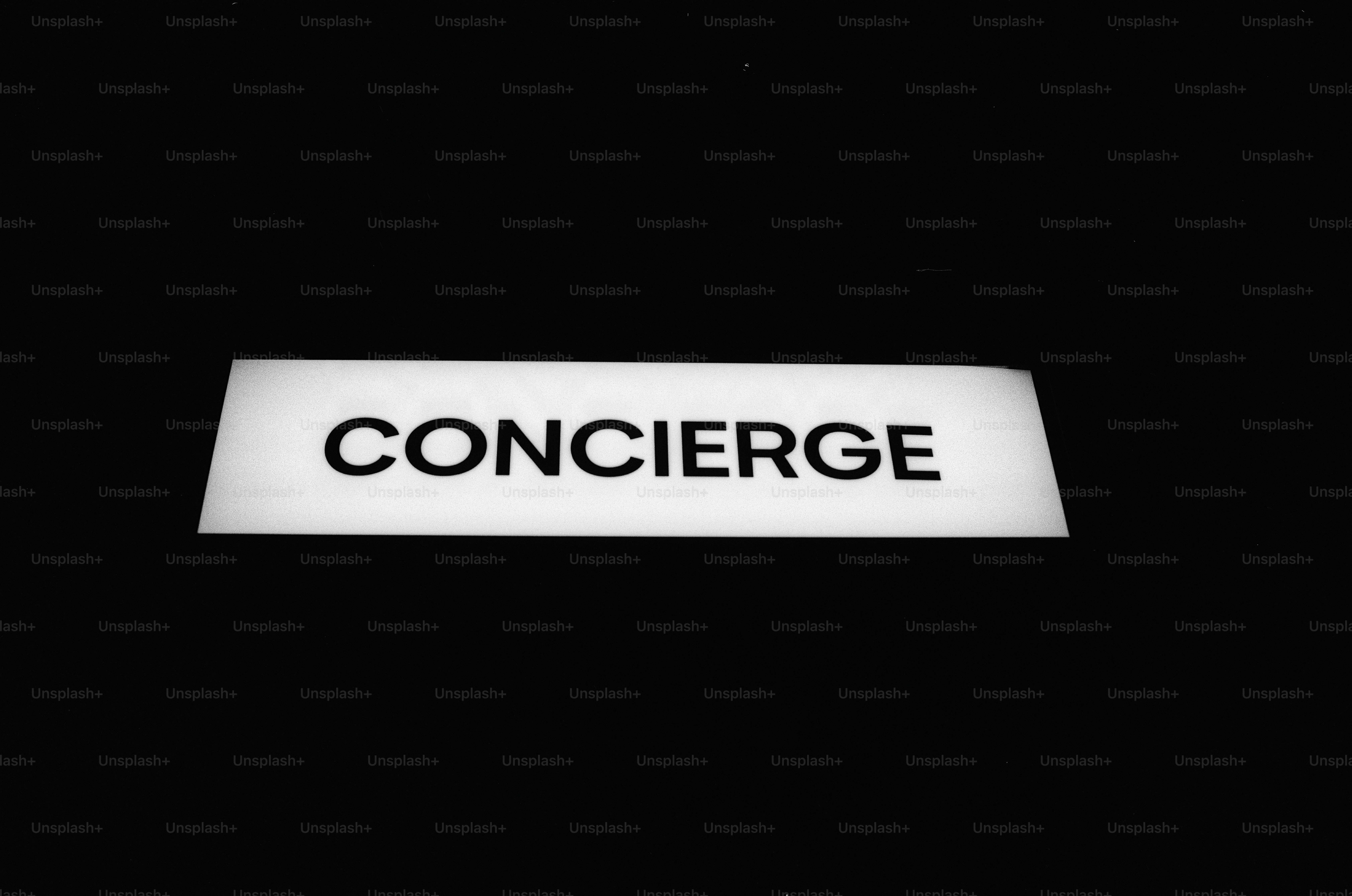 A glowing rectangular sign with the word CONCIERGE in black letters against darkness