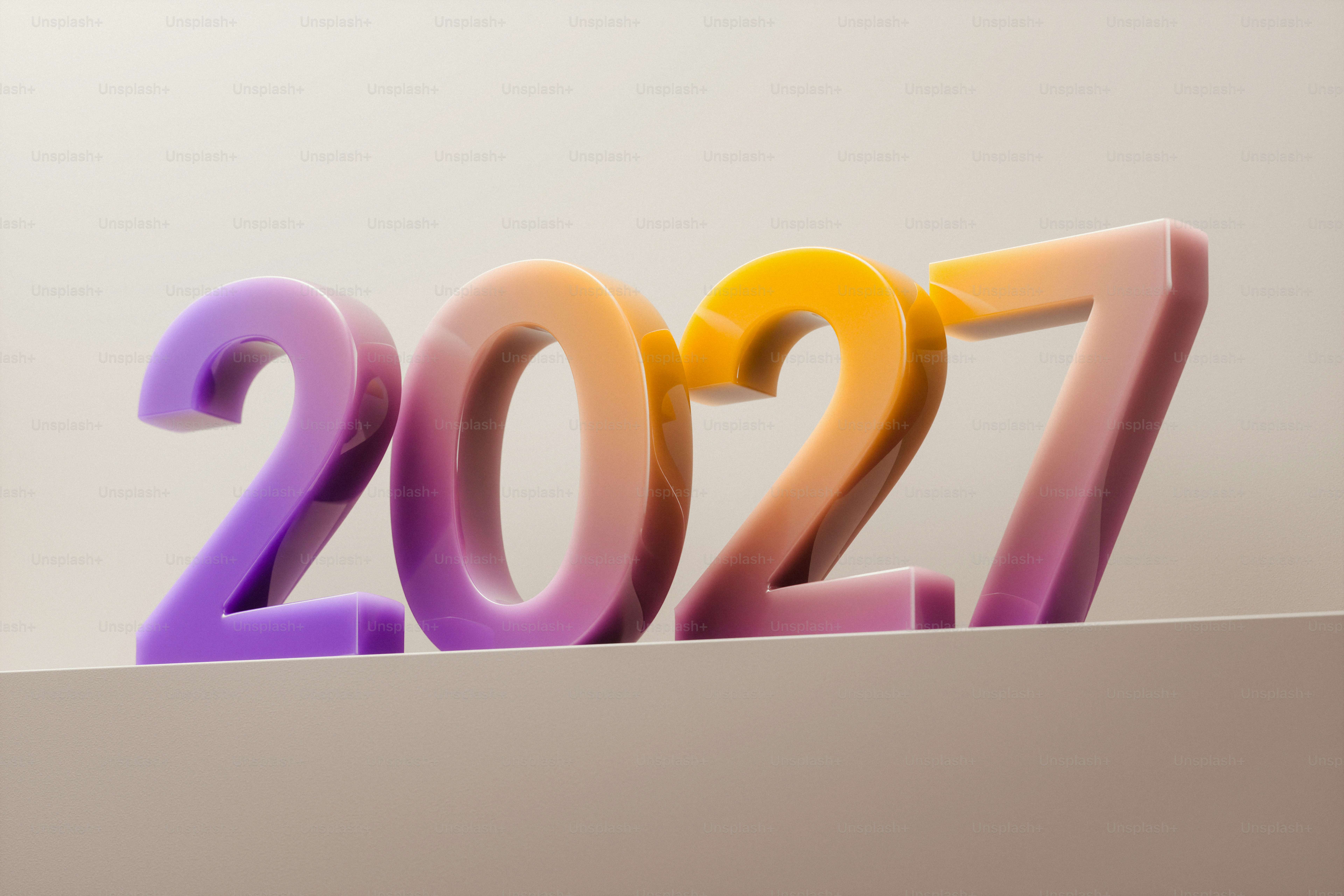 The numbers 2027 in a glossy purple and orange gradient on a ledge