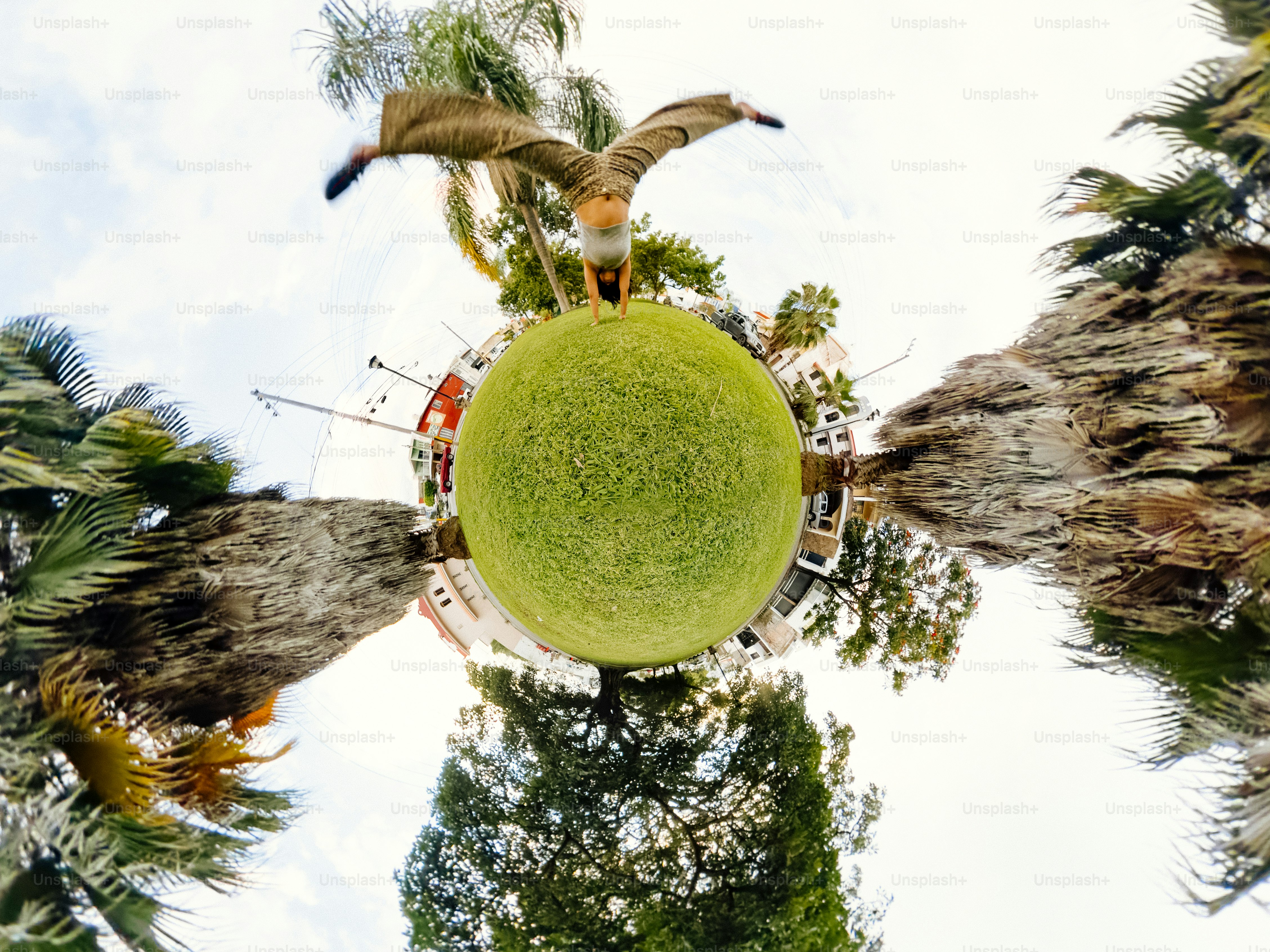 A person doing a handstand on a grassy lawn in a 360-degree panoramic view