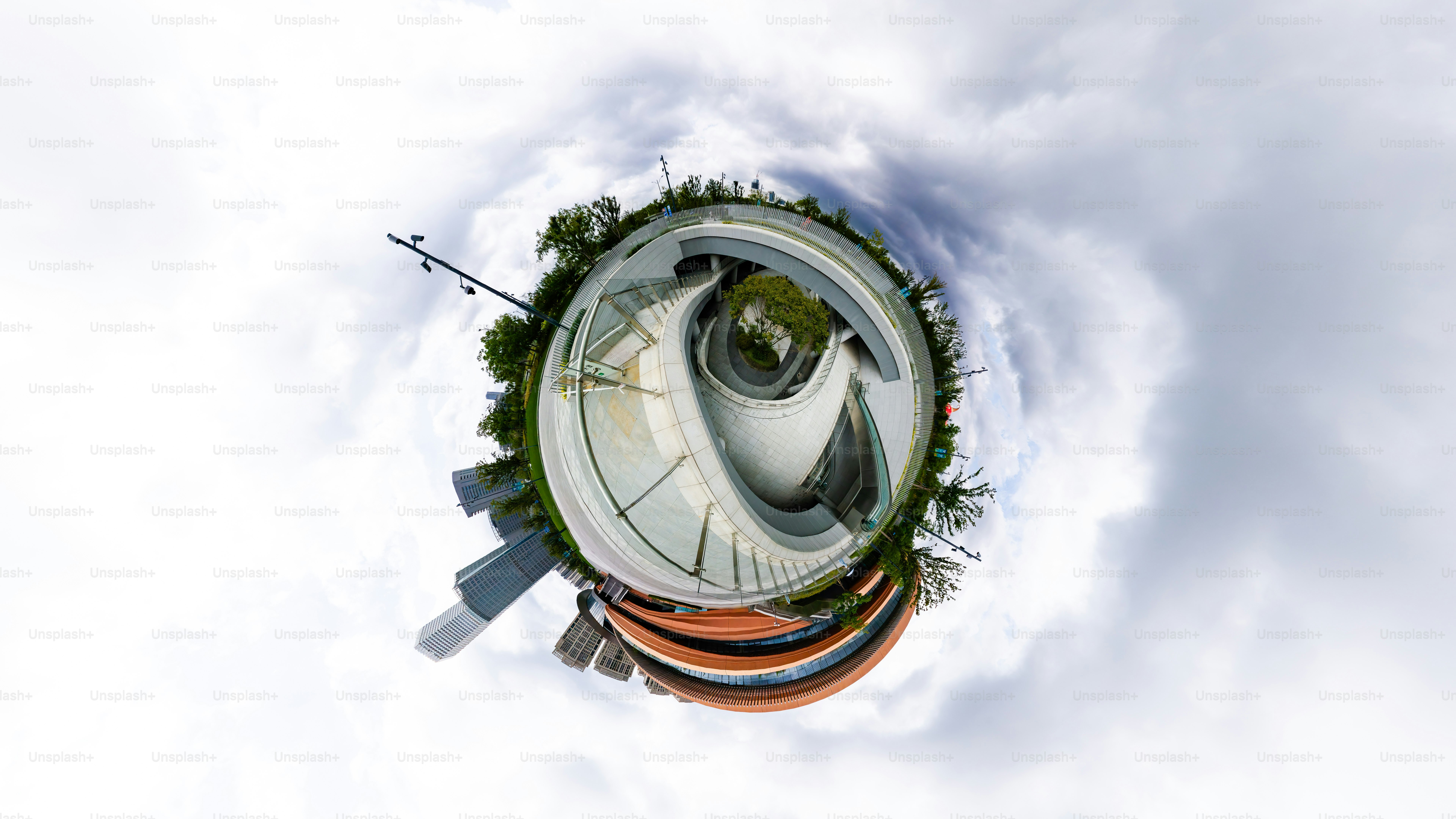 A 360-degree panoramic view of a modern circular building with trees and sky