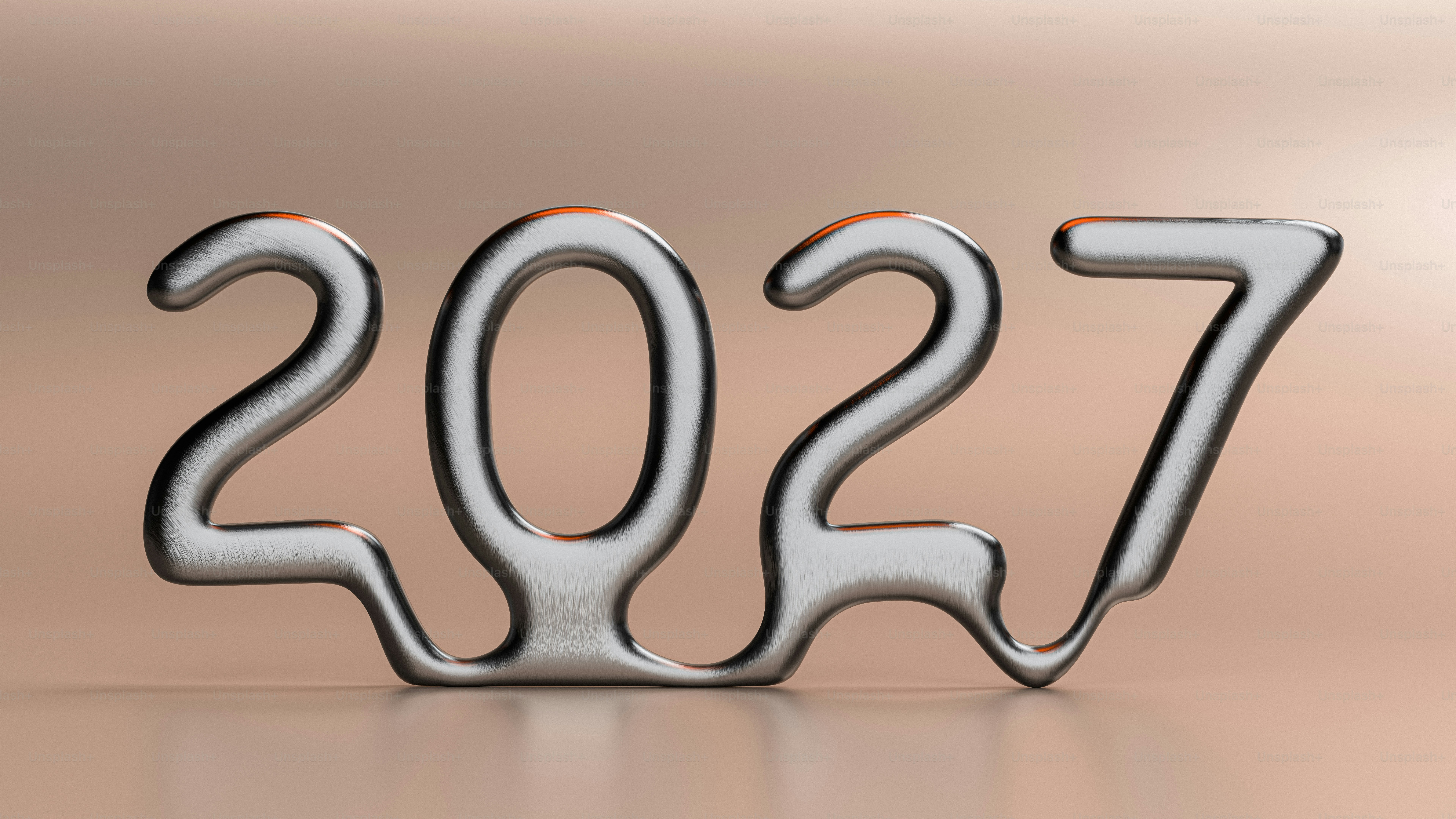 The numbers 2027 in a metallic liquid font on a smooth beige surface