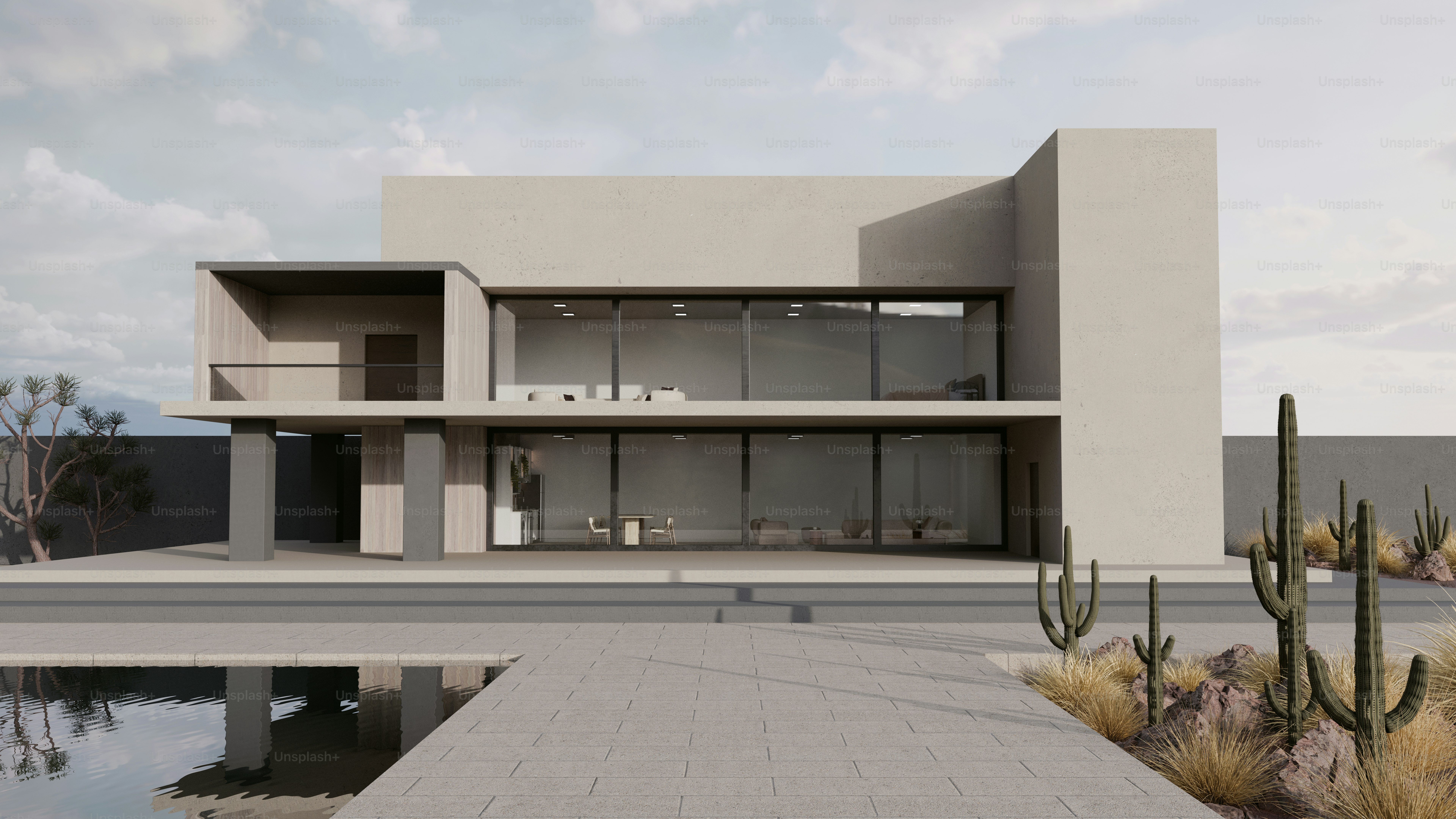 Une maison moderne à deux étages avec de grandes fenêtres vitrées dans un paysage désertique