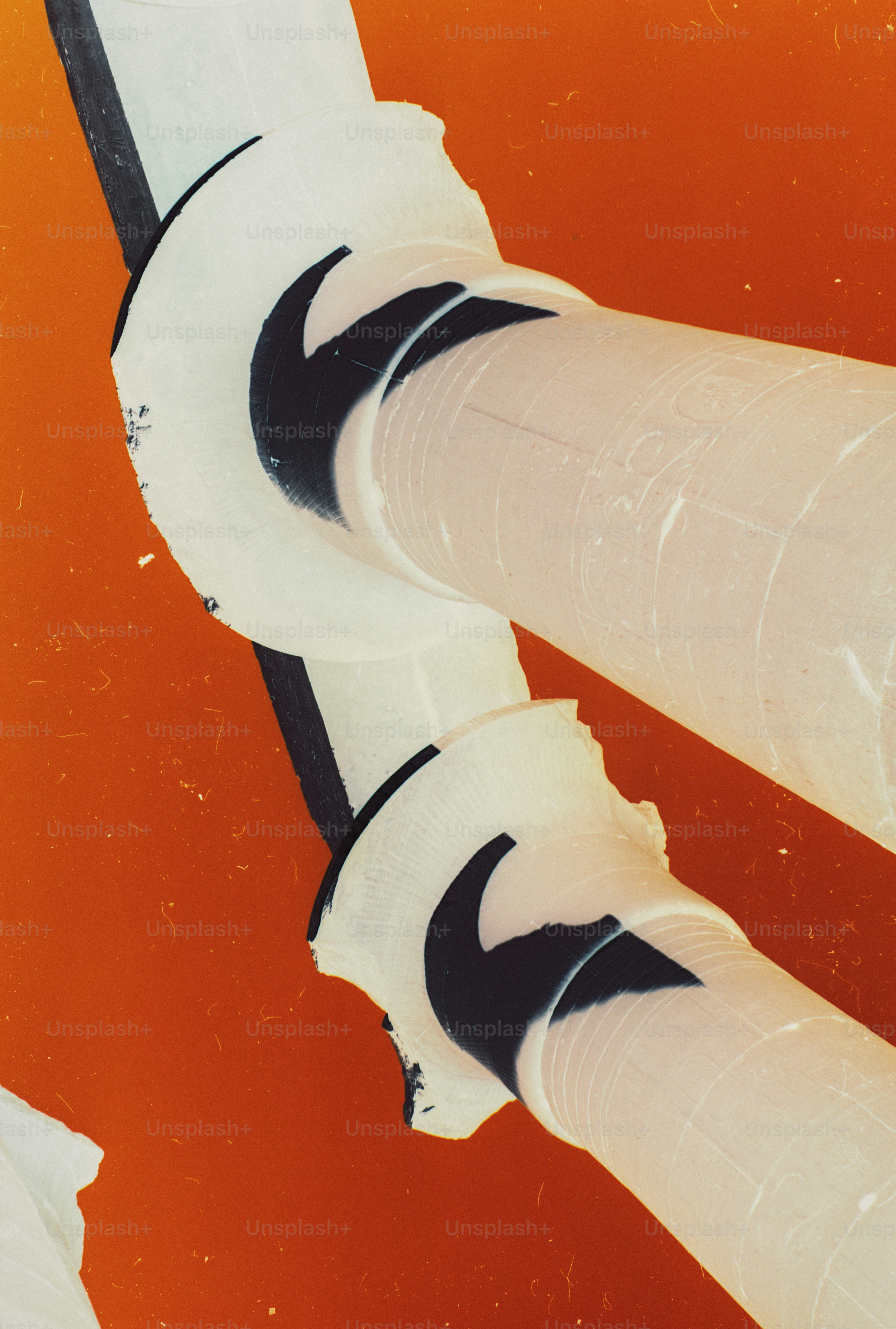 Two white socks with black swoosh logos against a vibrant orange background