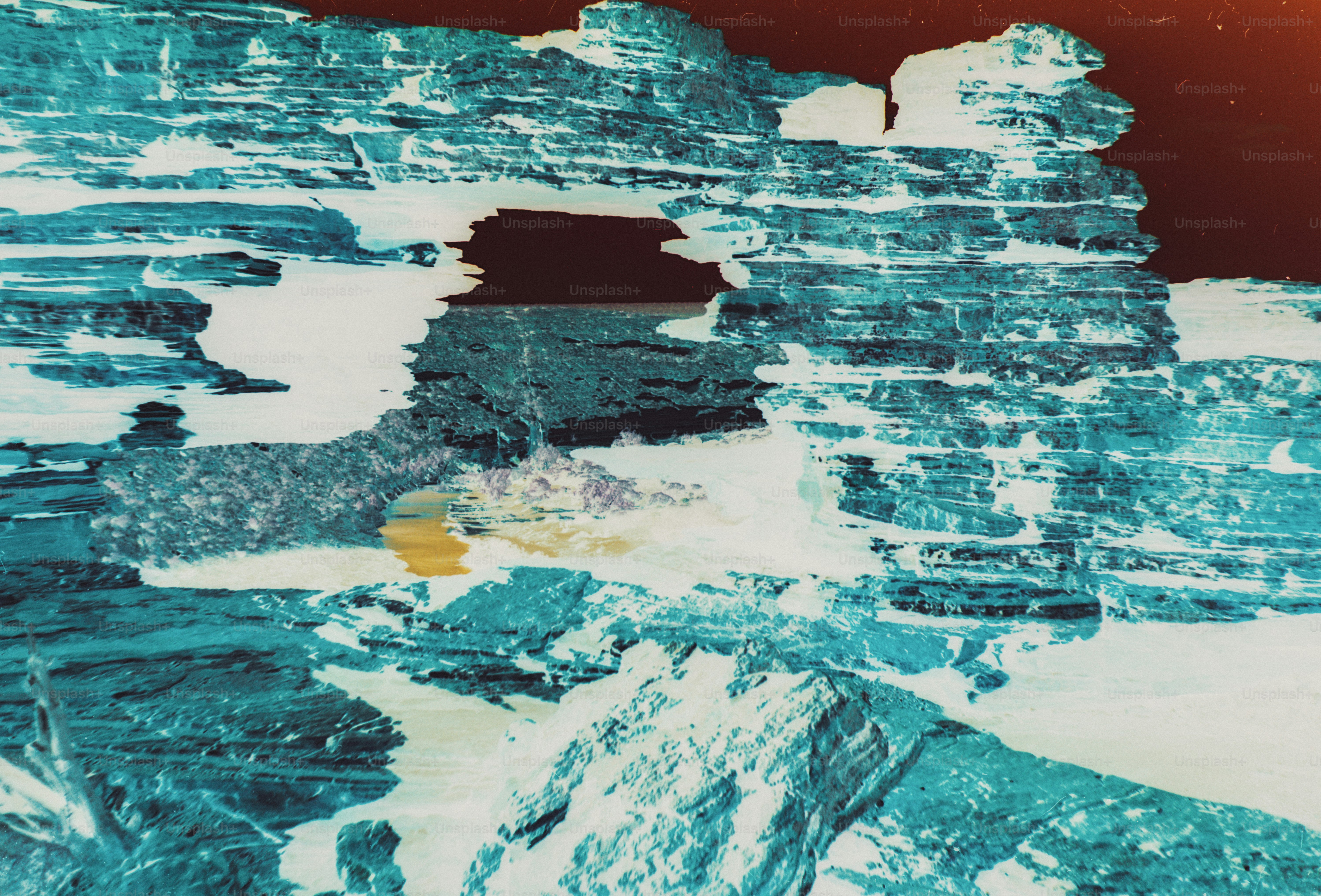 Blue and white inverted negative of layered rock formations with an arch