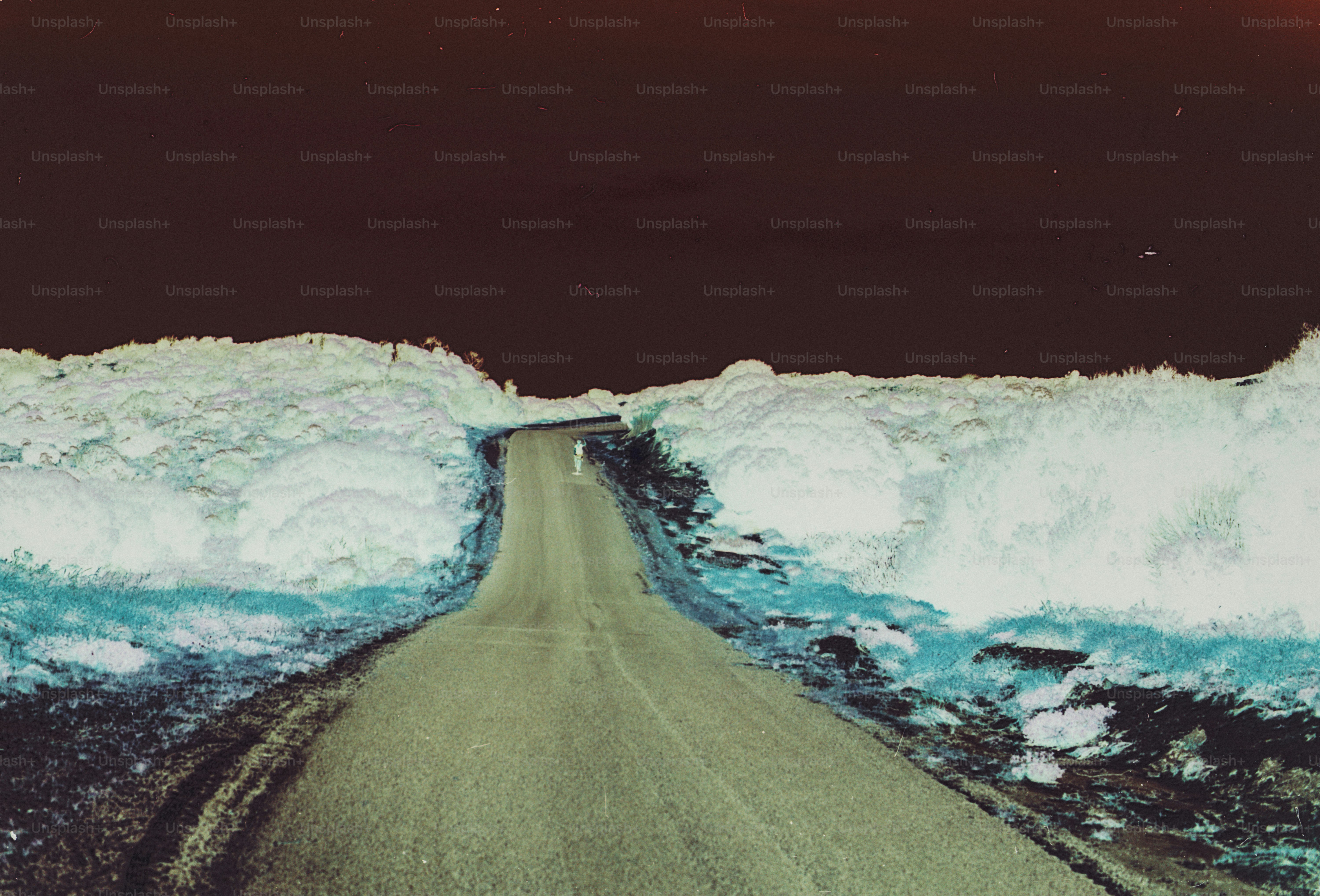 A paved road winding through a landscape with inverted colors and dark sky