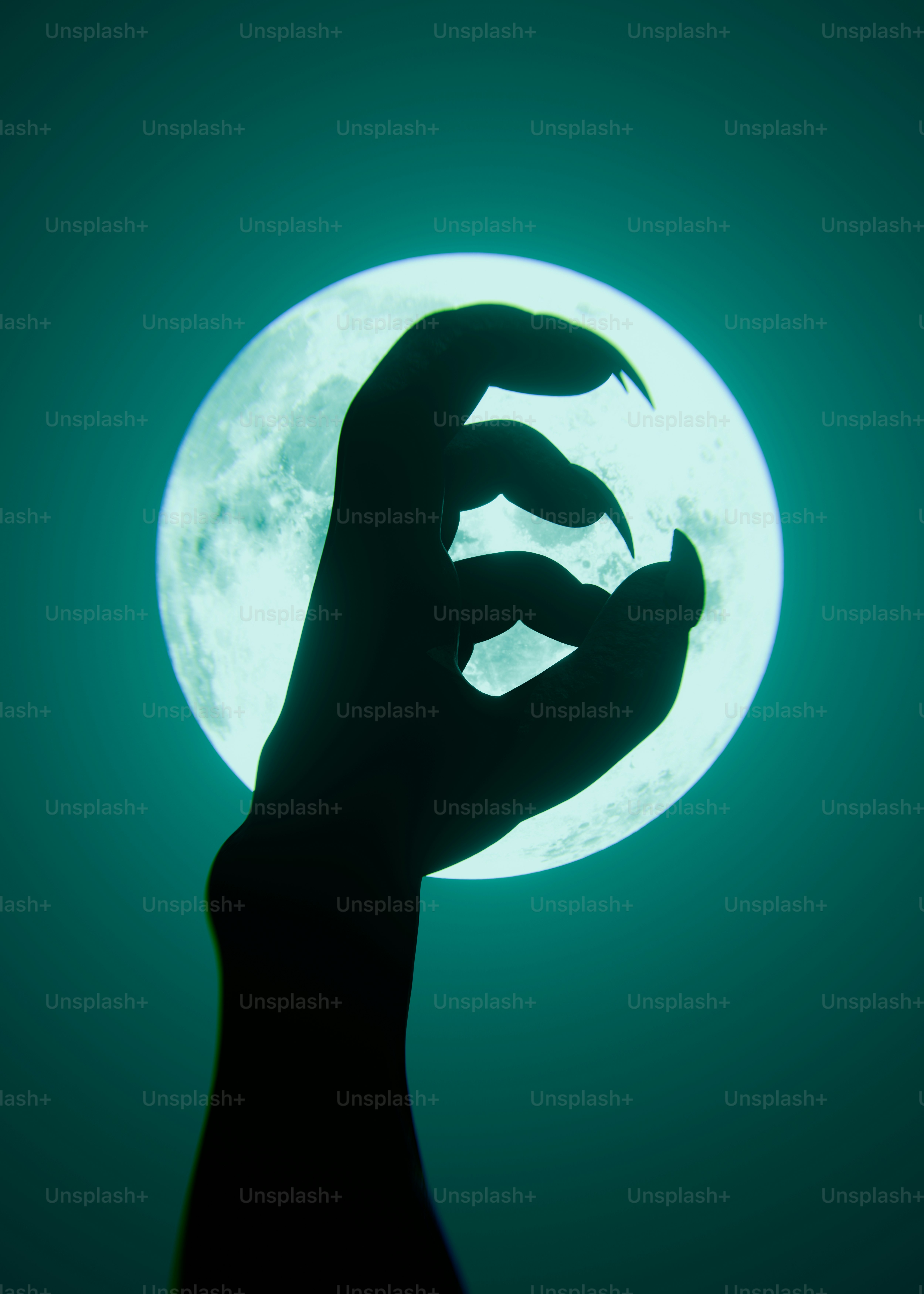 Une main griffue en silhouette contre une grande pleine lune lumineuse