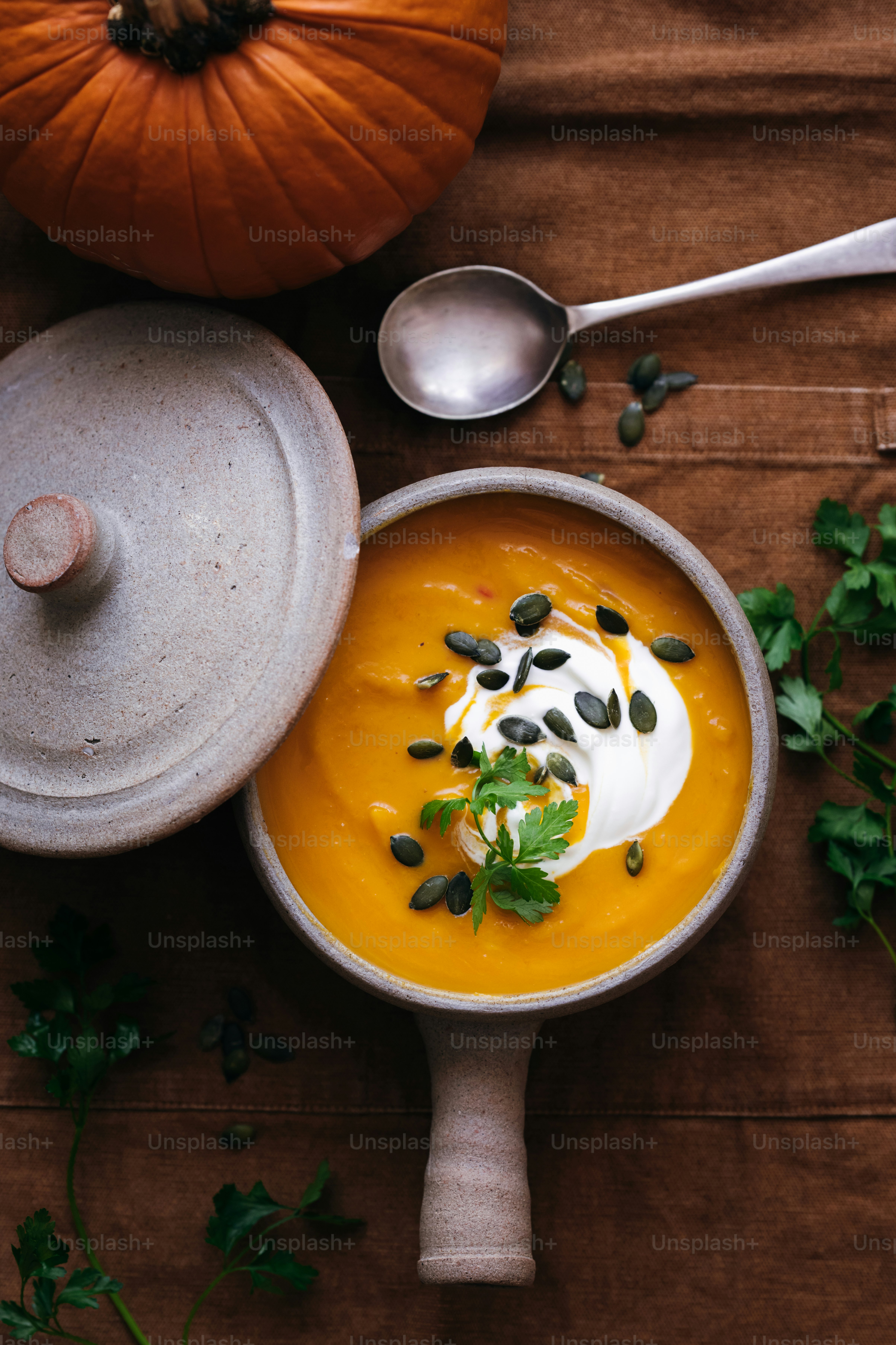 Soupe à la citrouille dans un bol en céramique avec de la crème, des graines et du persil