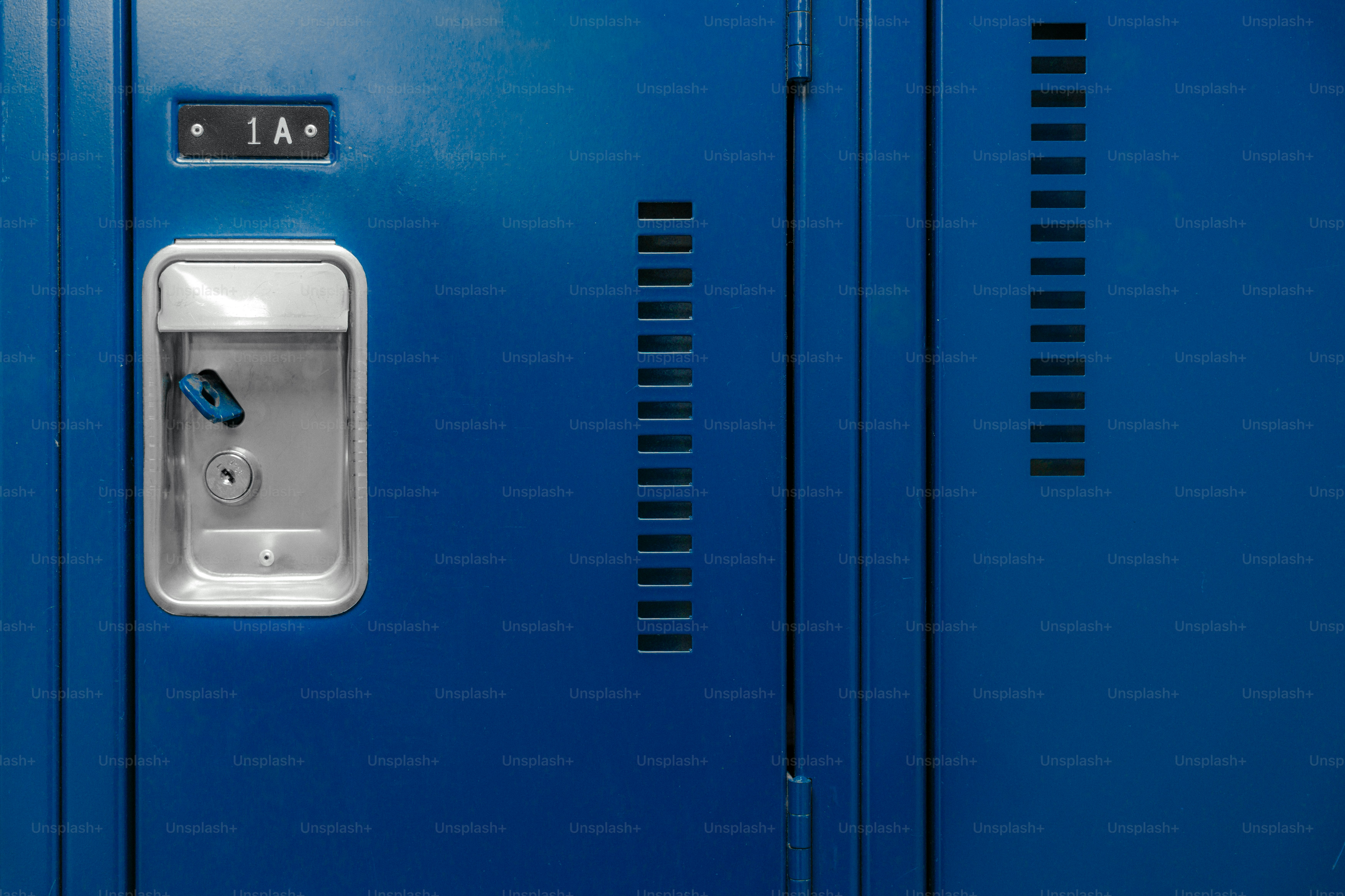 A blue metal locker with a silver handle and a key labeled 1 A