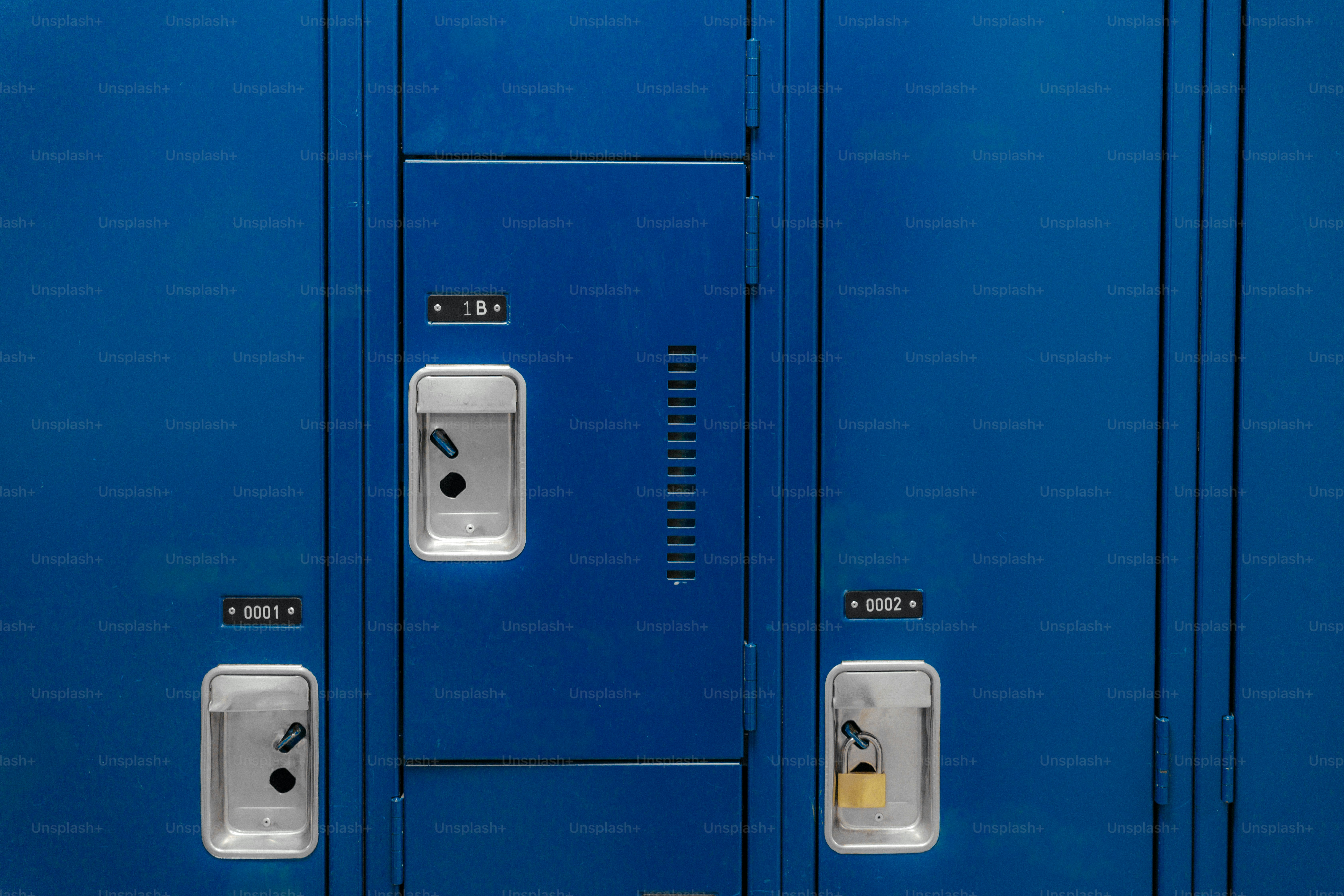 Three blue metal lockers with silver handles and numbered identification plates