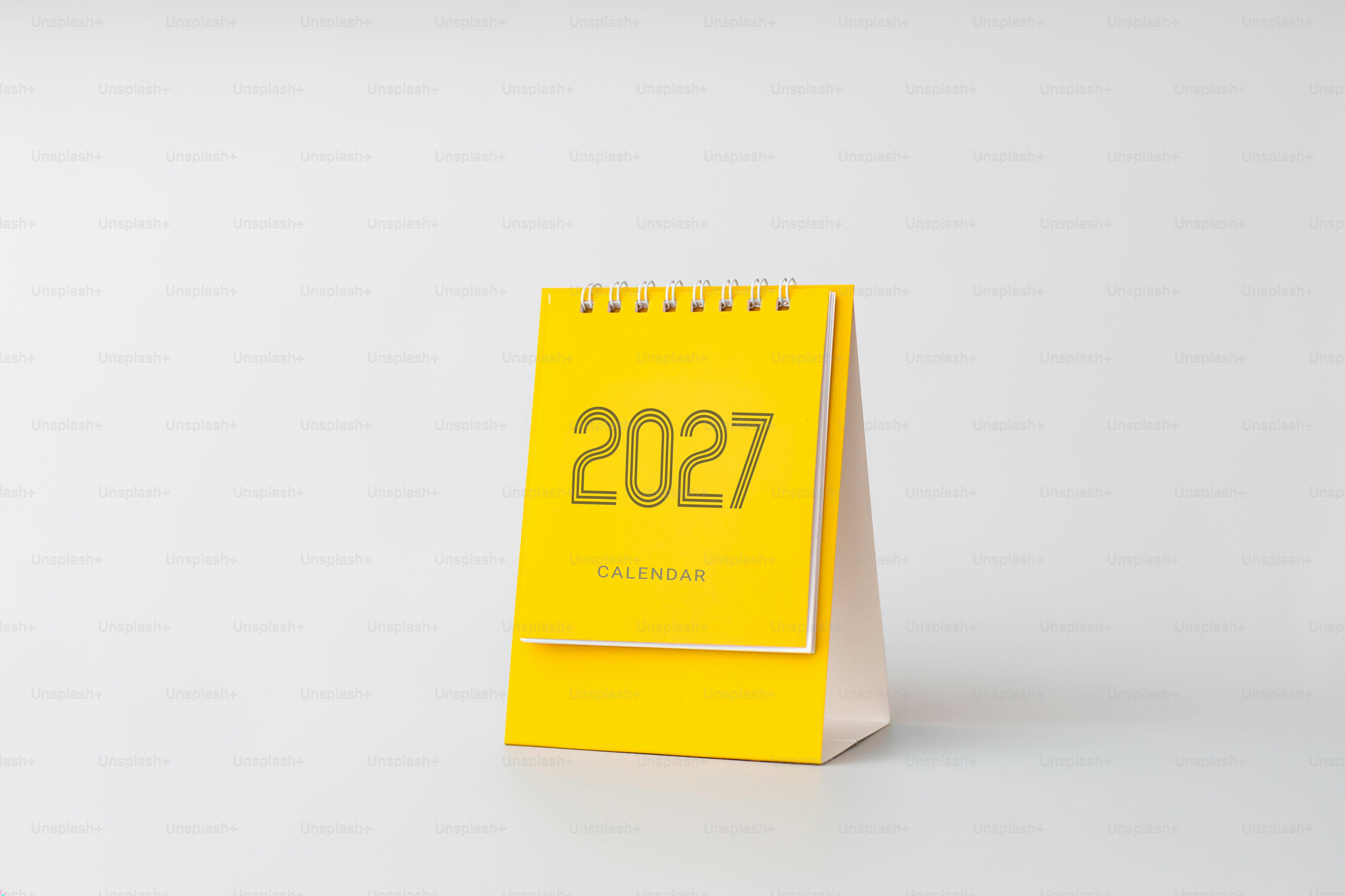 A yellow desk calendar with the year 2027 printed on the front cover