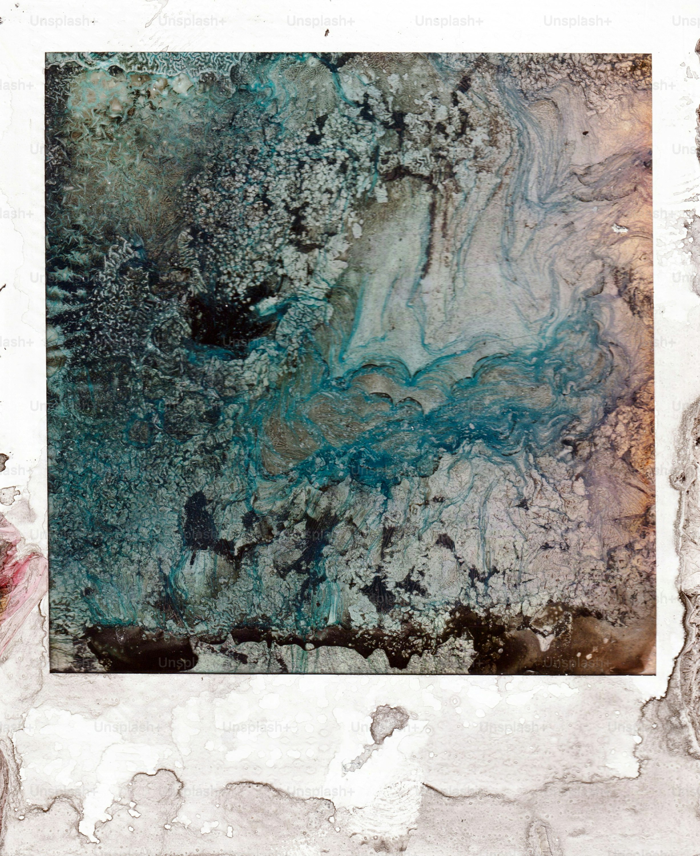 Abstract swirls of blue and brown ink on a textured white surface