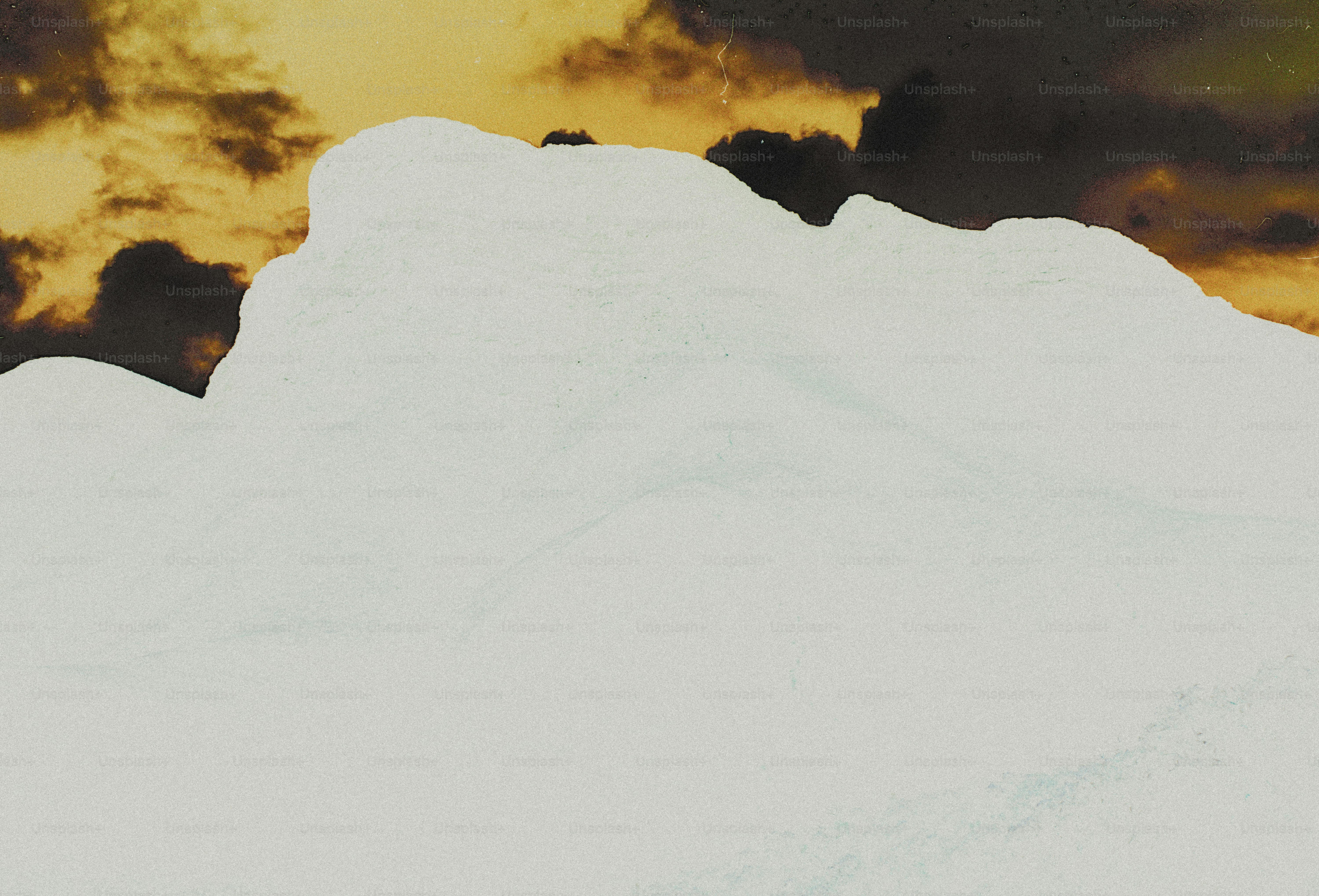 A white paper tear revealing a dark golden sky with clouds