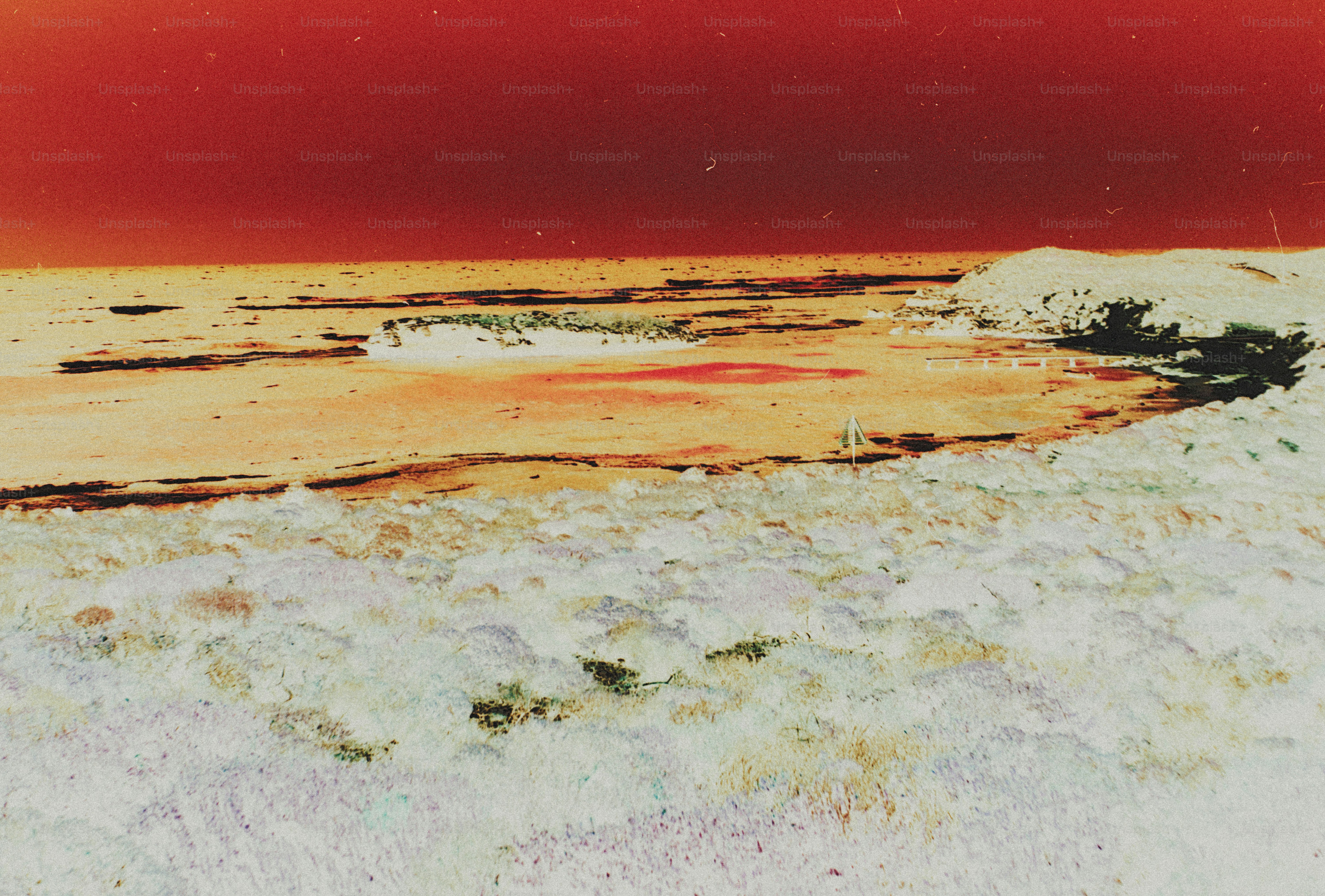 An inverted color landscape of a sandy beach with a small rocky island