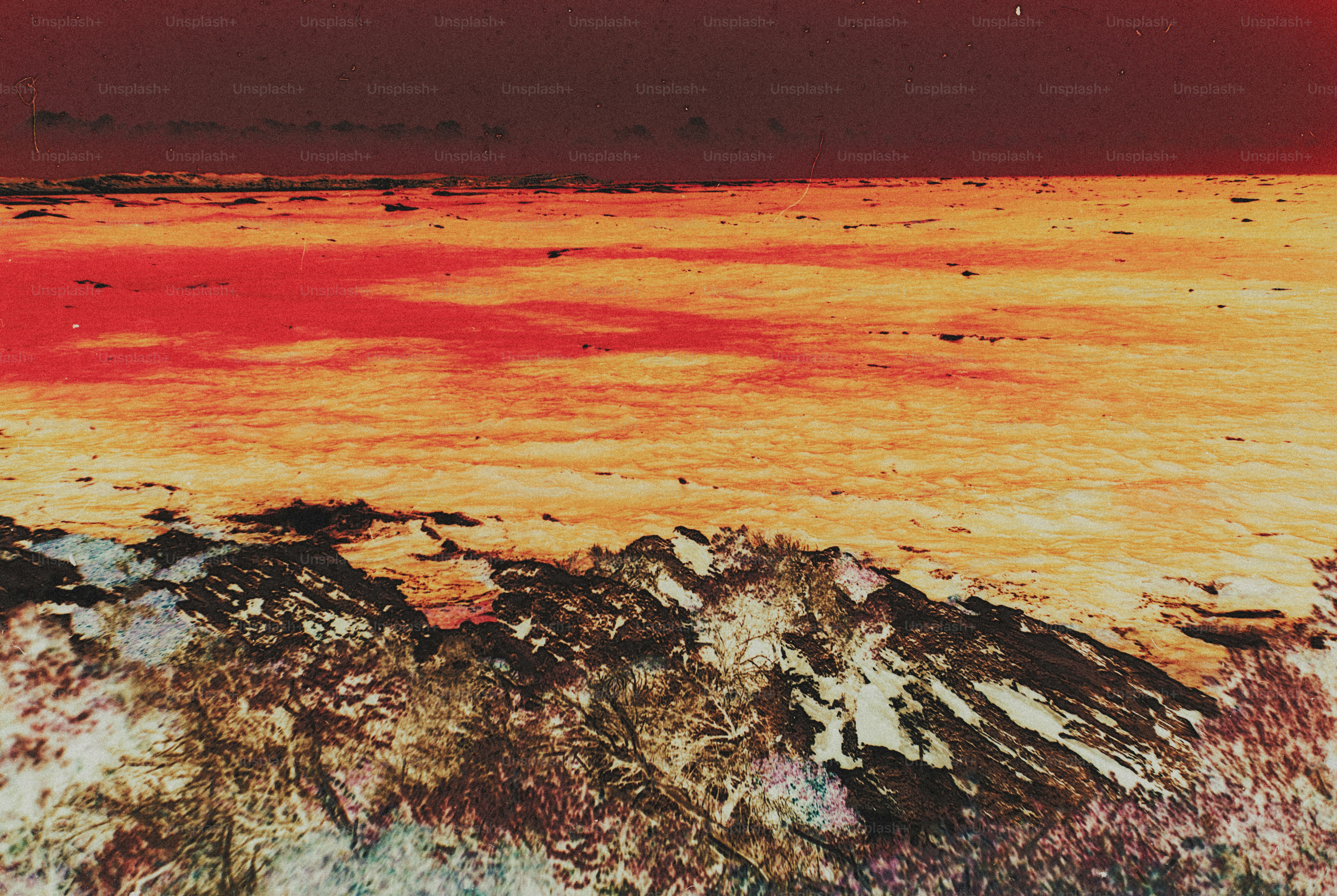 A rocky coastline overlooking a vast expanse of water under a dark sky