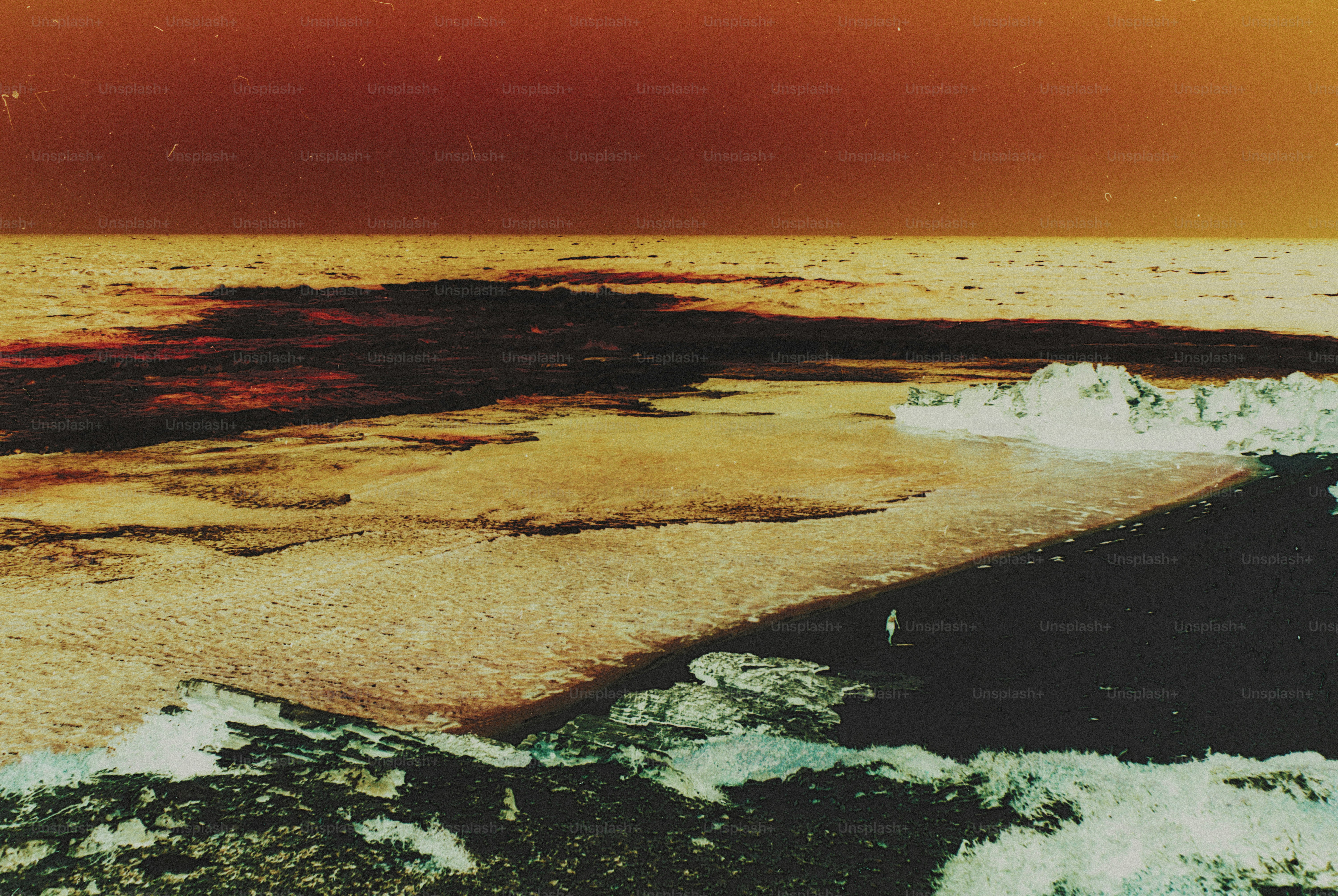 A person on a dark beach with waves crashing against the shore