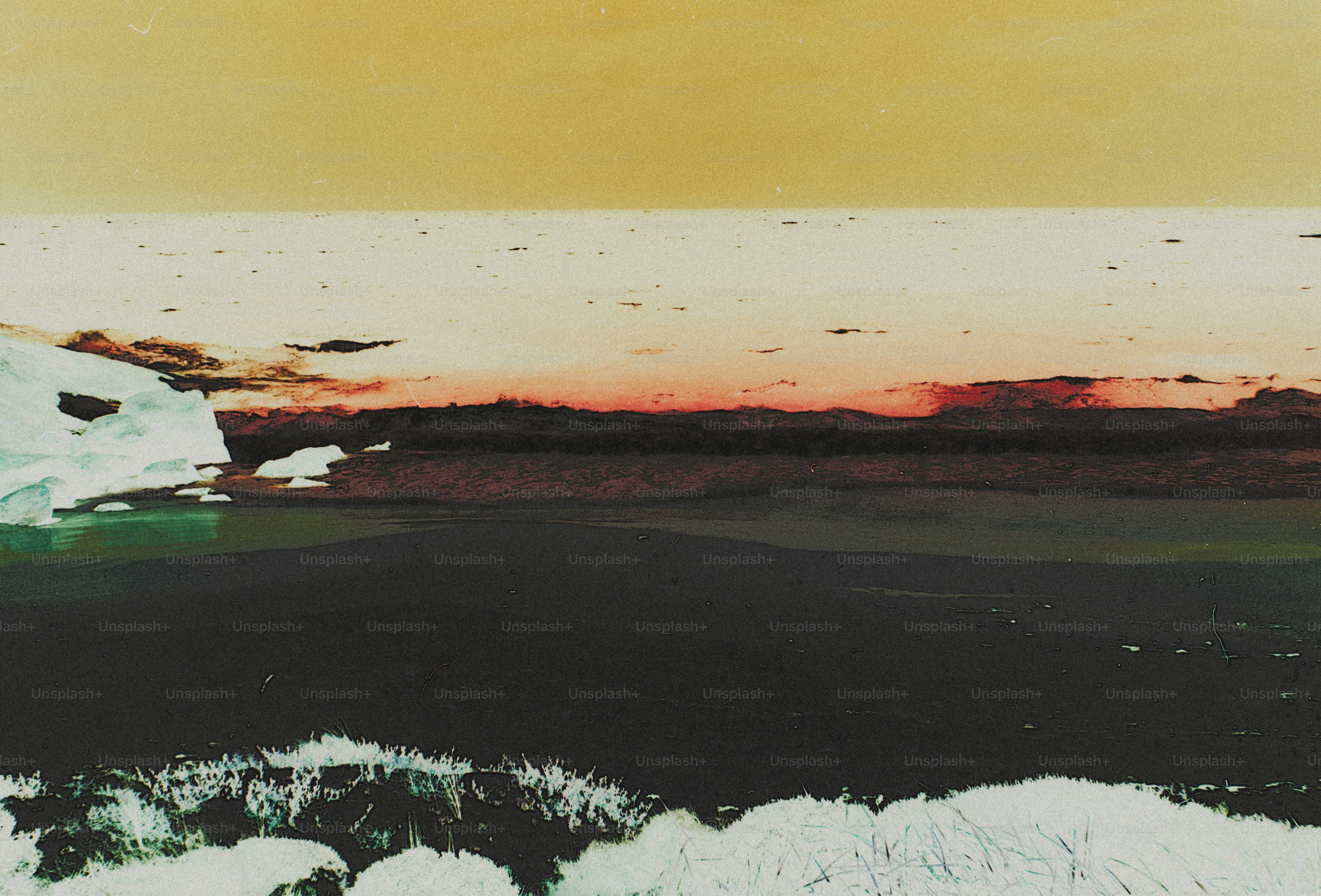 A dark landscape with ice formations under a warm orange and yellow sky