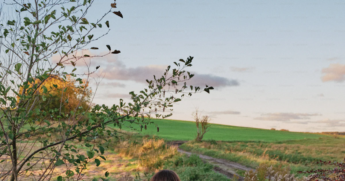 Person in cream sweater leaning on fence - Photo on Unsplash+