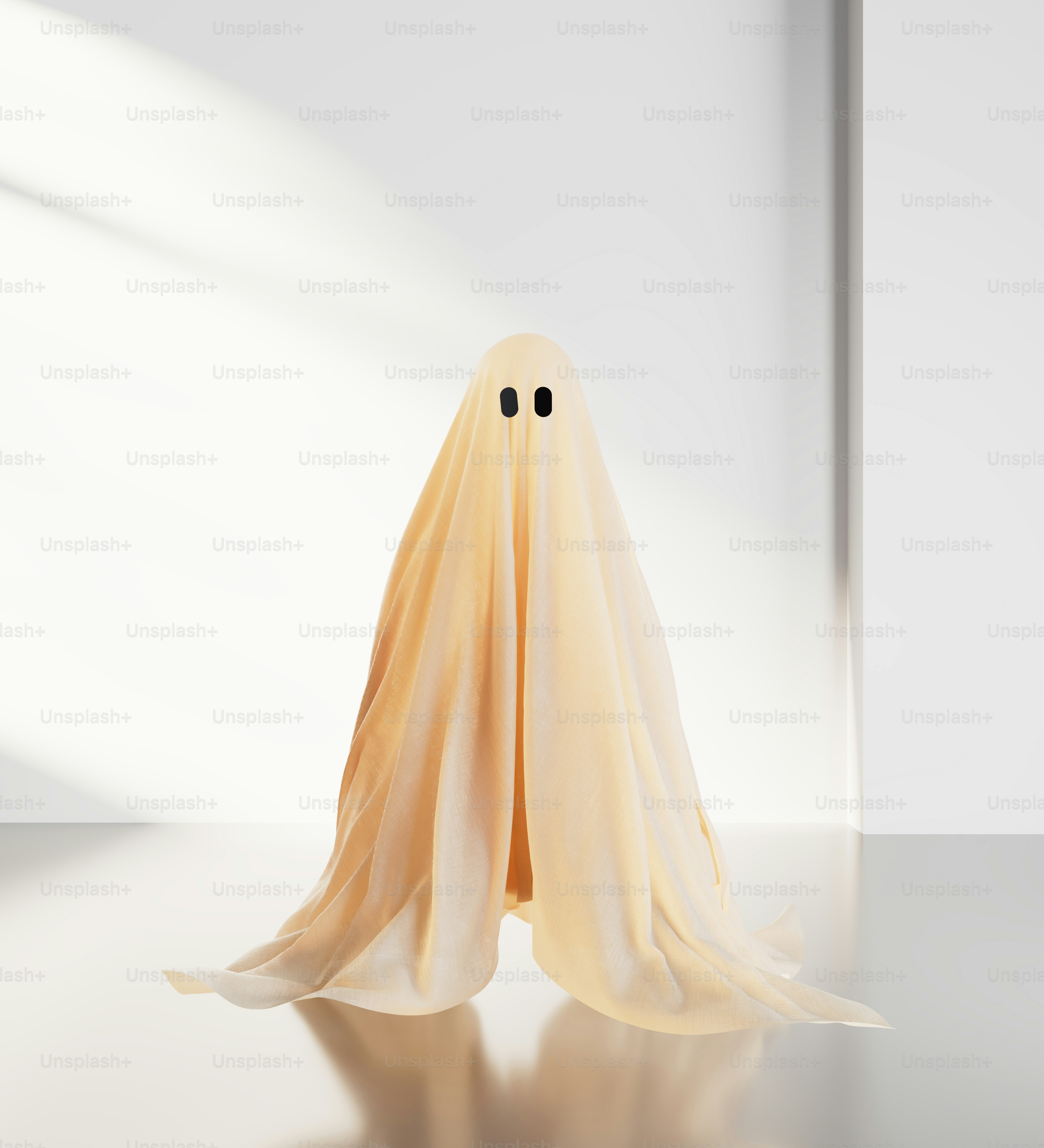 A person in a beige sheet ghost costume against a plain white wall
