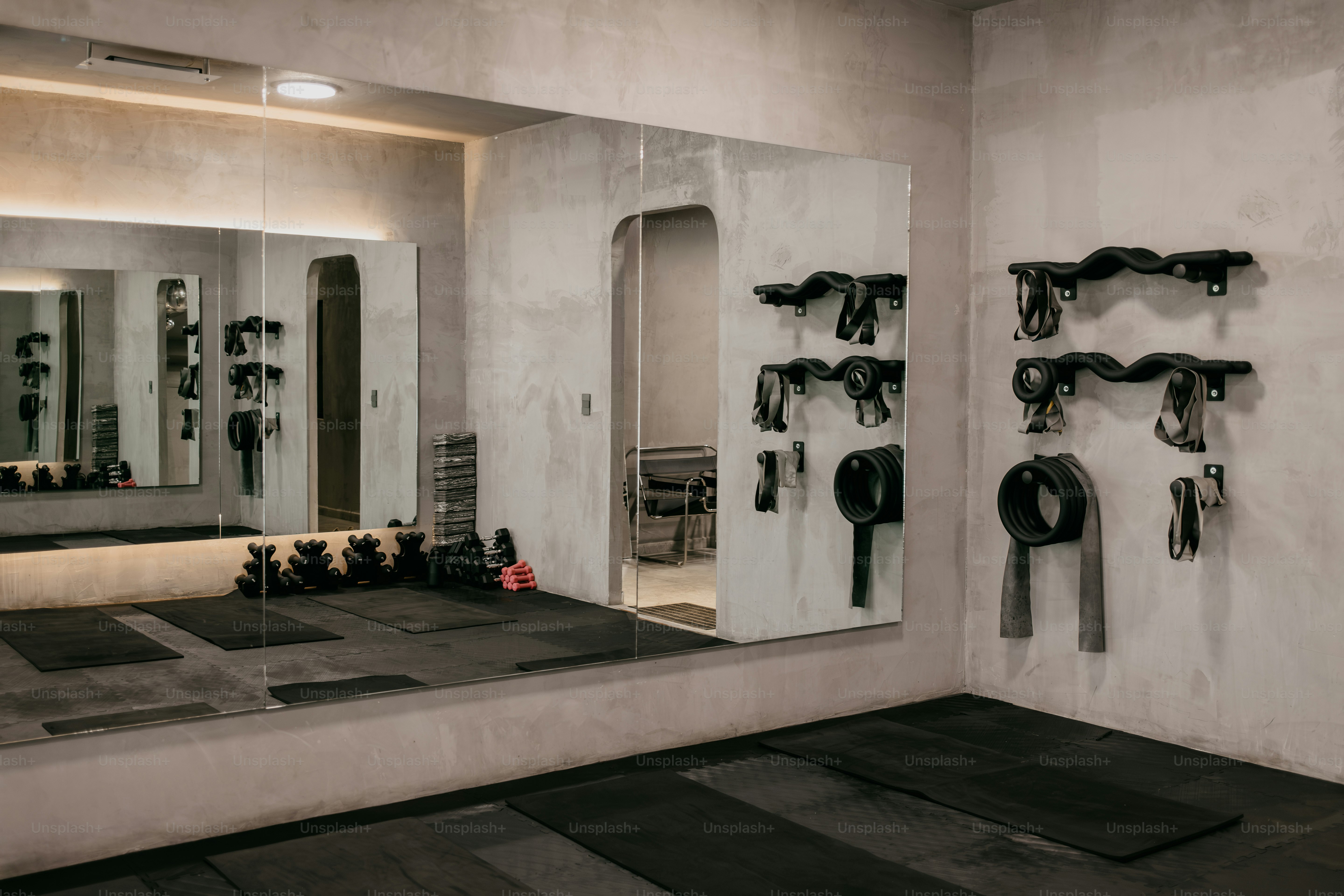 Fitnessgeräte und Widerstandsbänder, die an einer Betonwand in einem Studio montiert sind