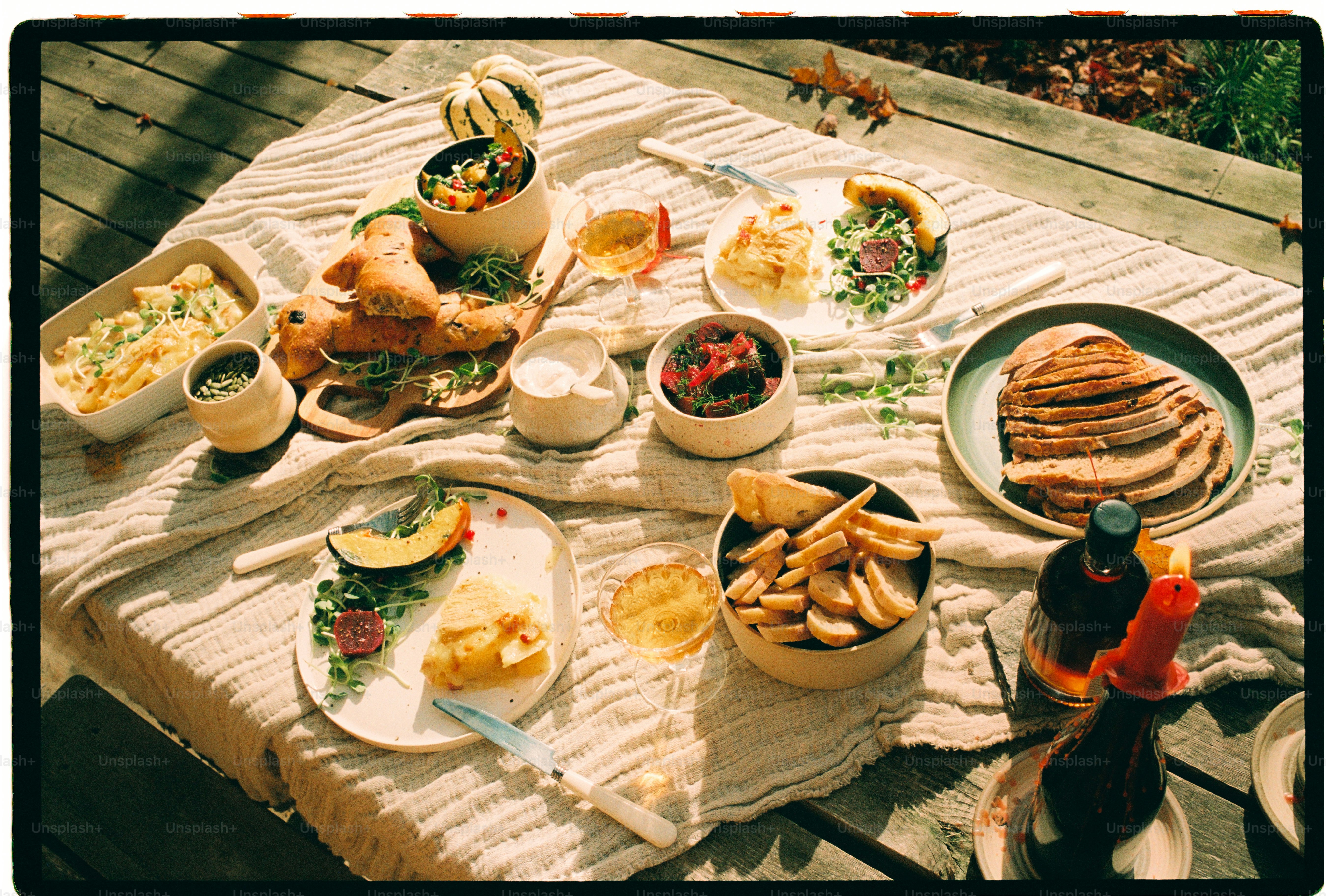 Un picnic con pane, verdure arrosto e vino su un panno testurizzato