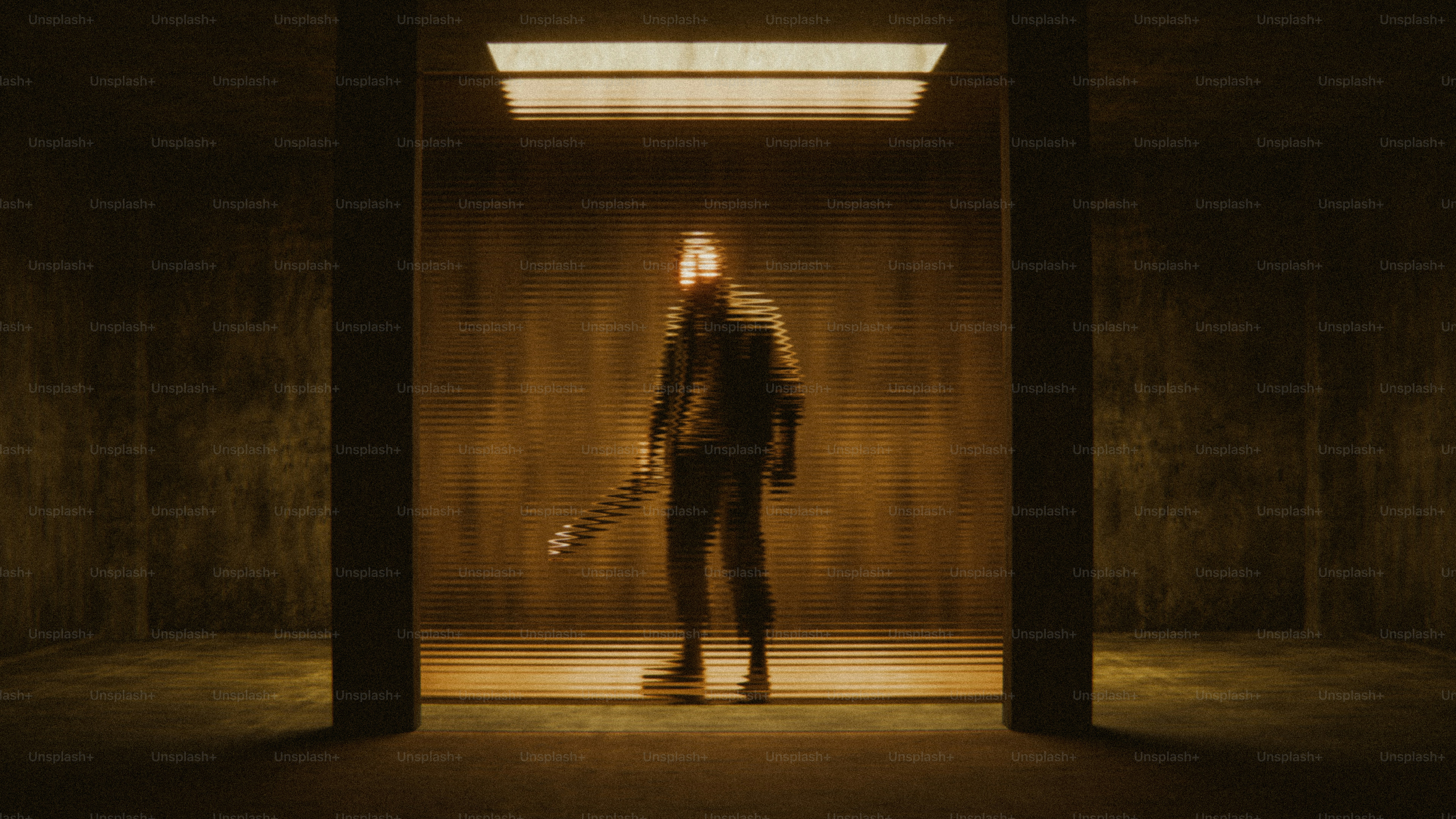A person in silhouette behind a ribbed glass panel in a dark room