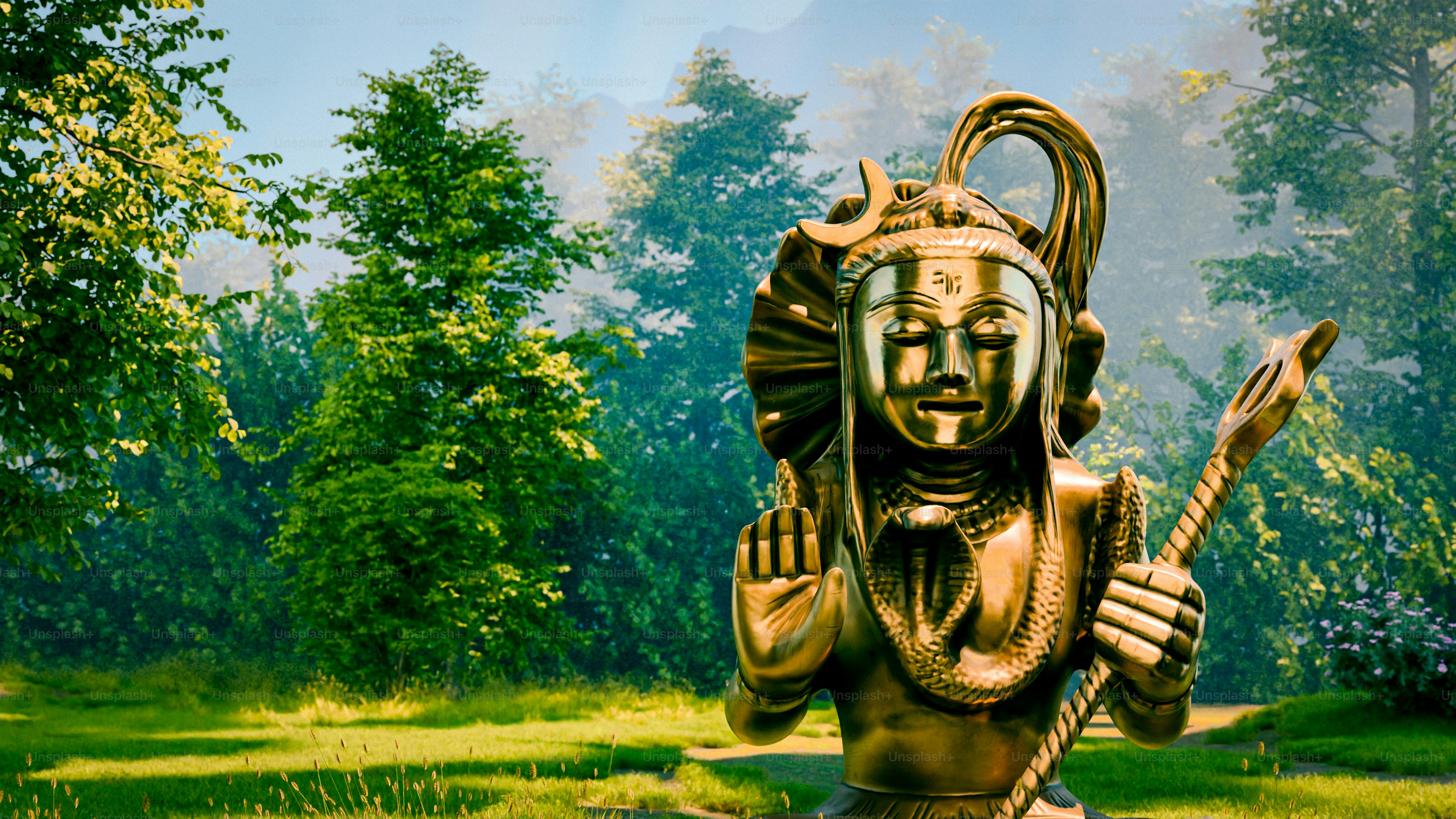 A golden statue of Shiva with a cobra in a sunlit forest clearing