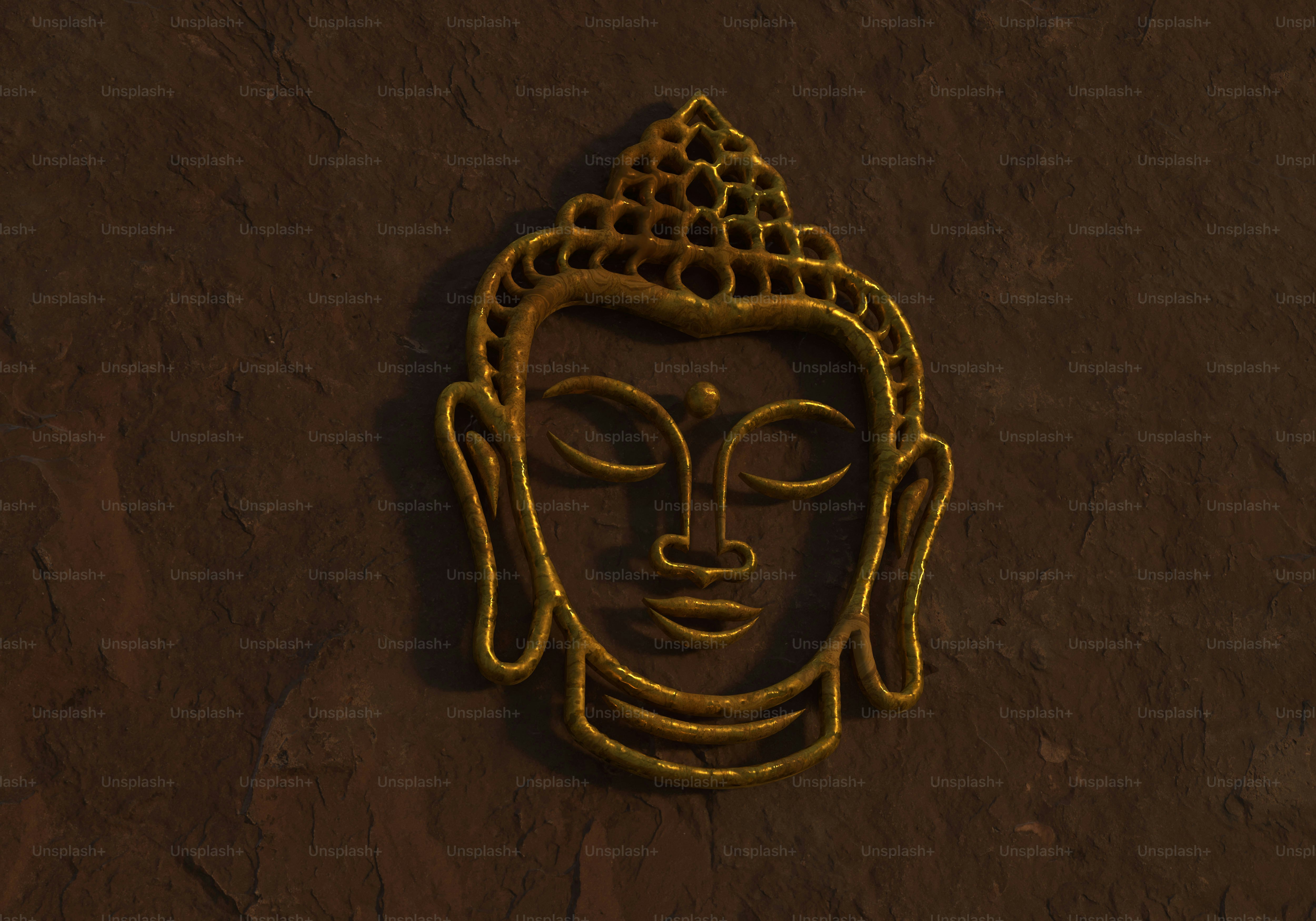 A golden Buddha head relief mounted on a dark textured stone wall
