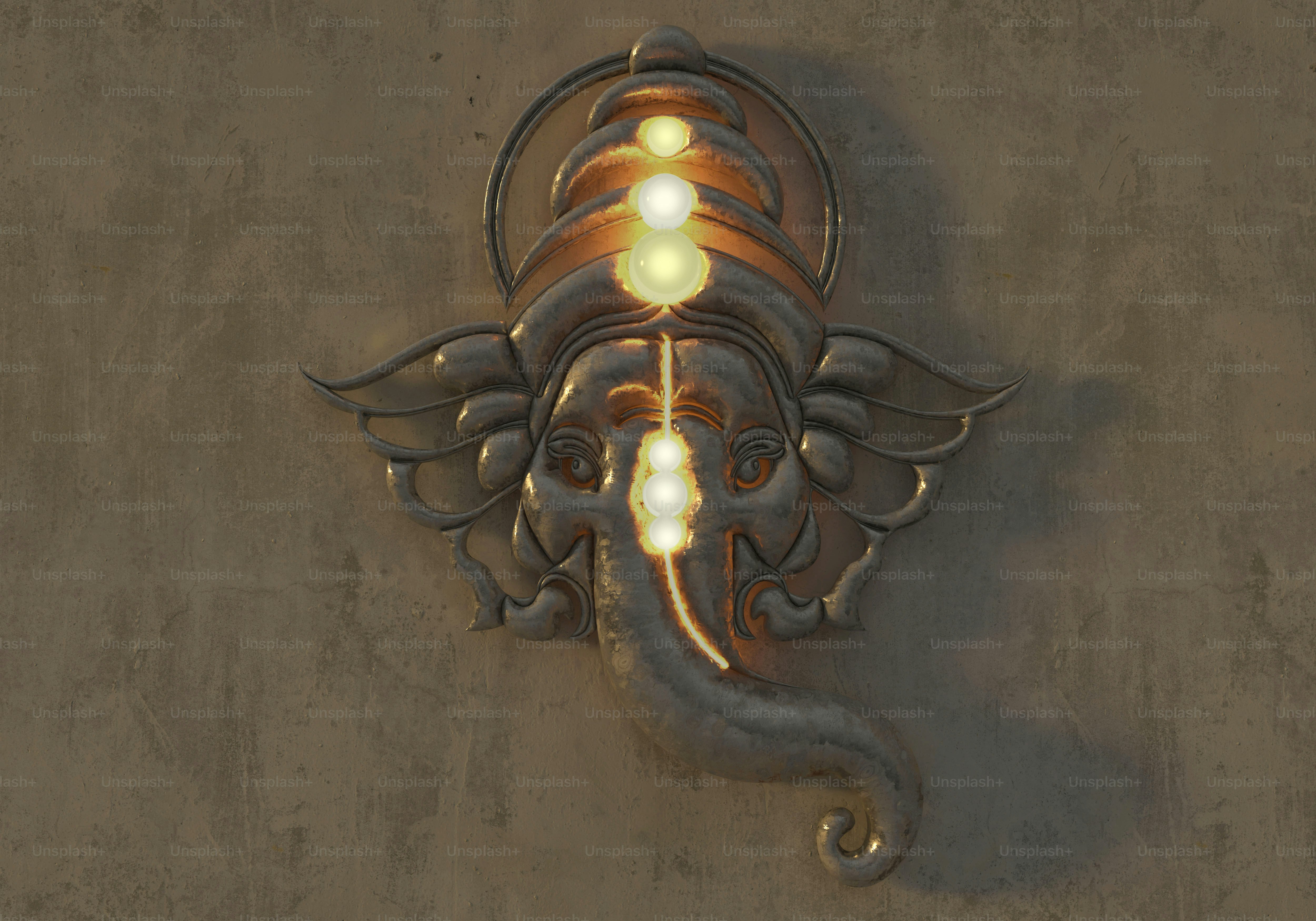 A metallic Ganesha wall sculpture with glowing light accents on a textured surface