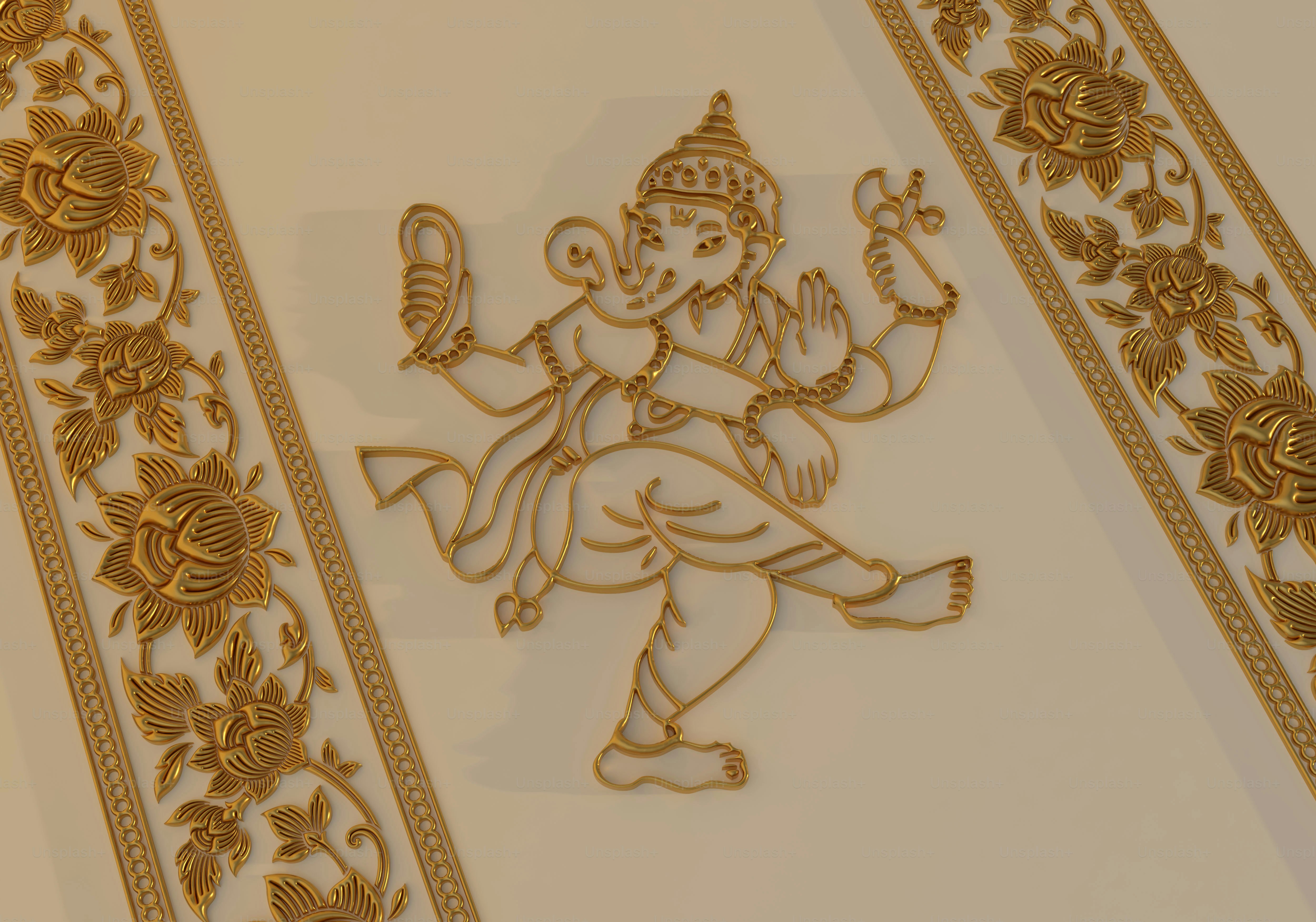 A gold relief of Ganesha dancing between two vertical floral borders on a wall
