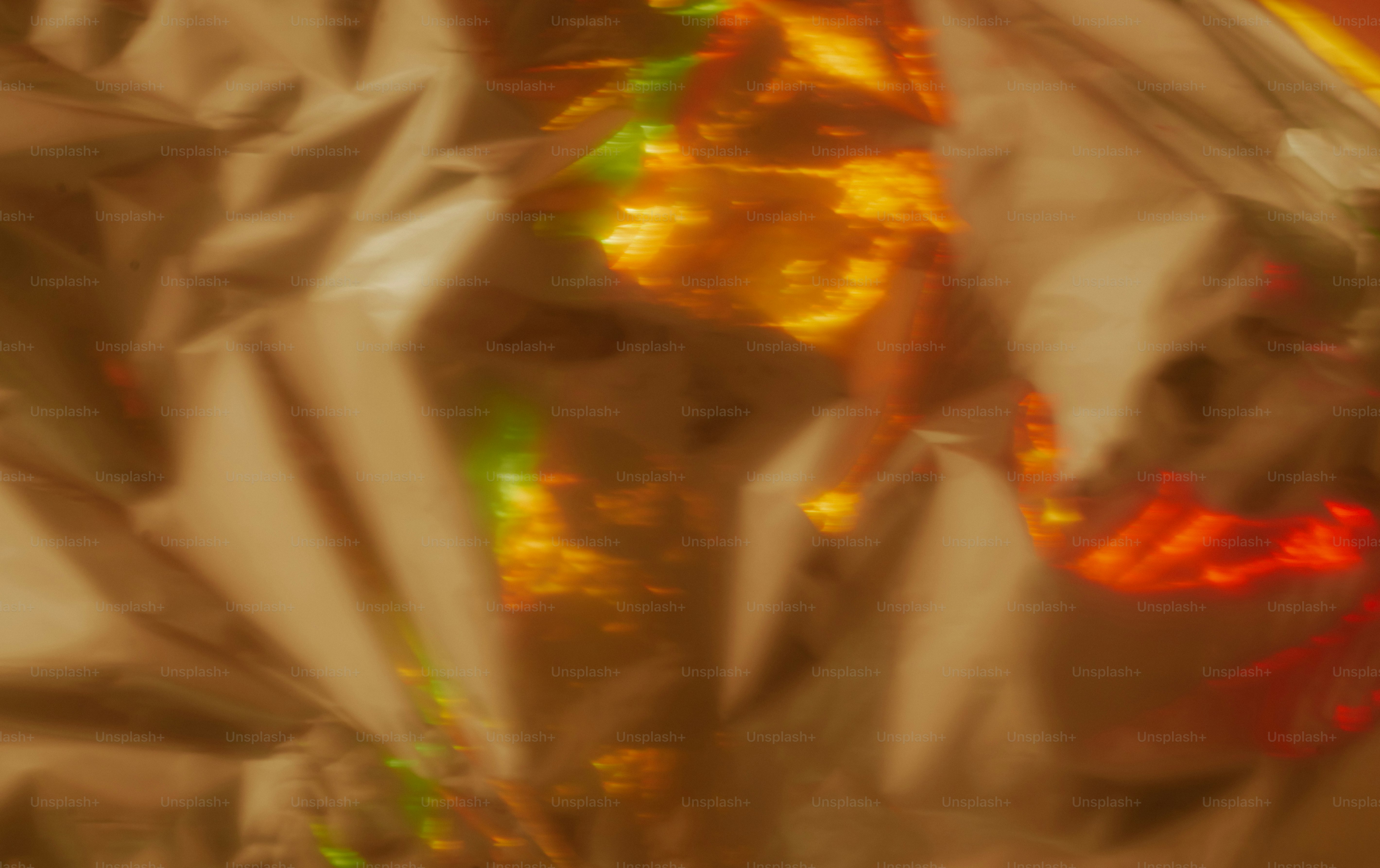 Abstract crumpled beige paper surface with glowing orange and green light reflections