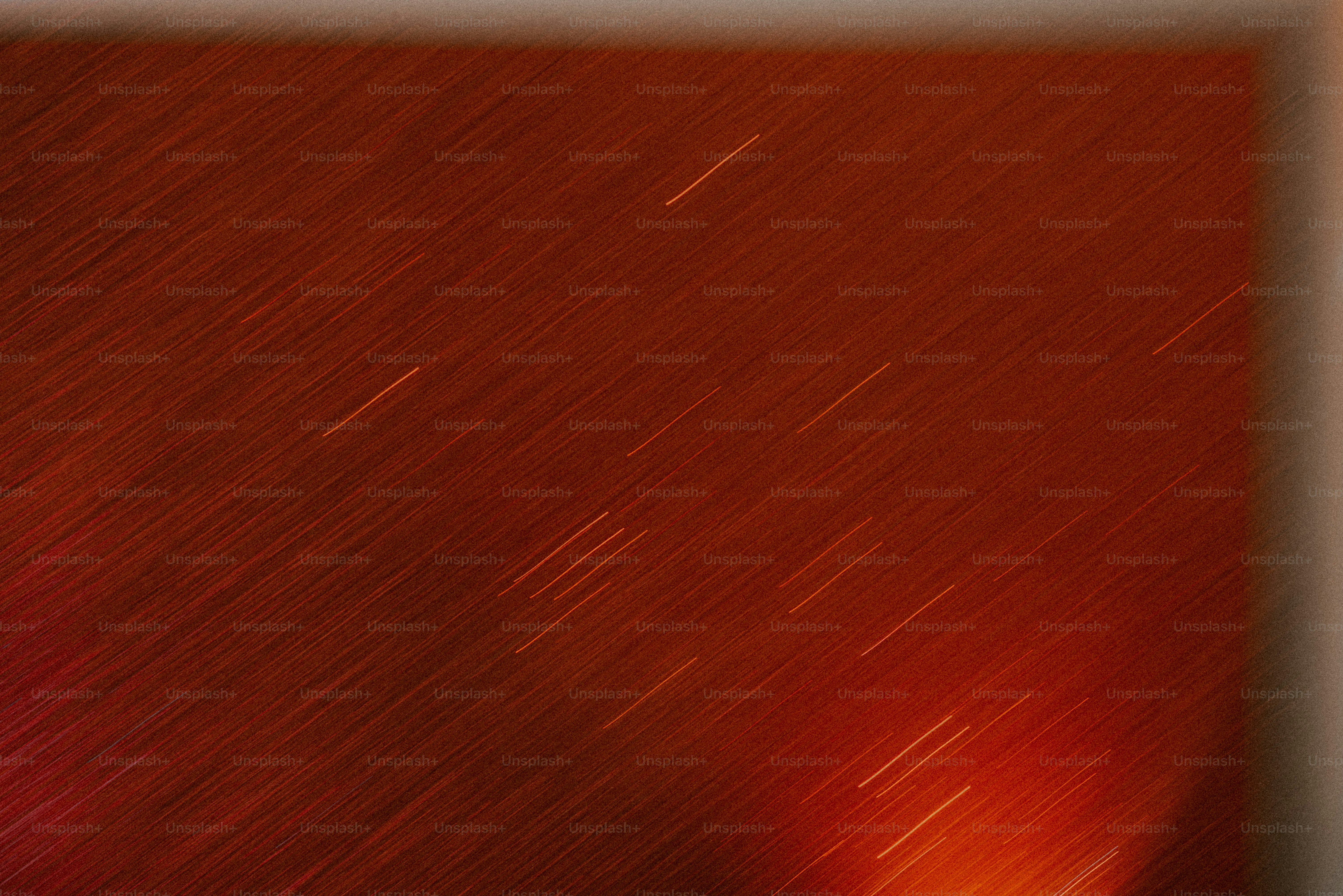 Diagonal streaks of light across a dark red textured surface