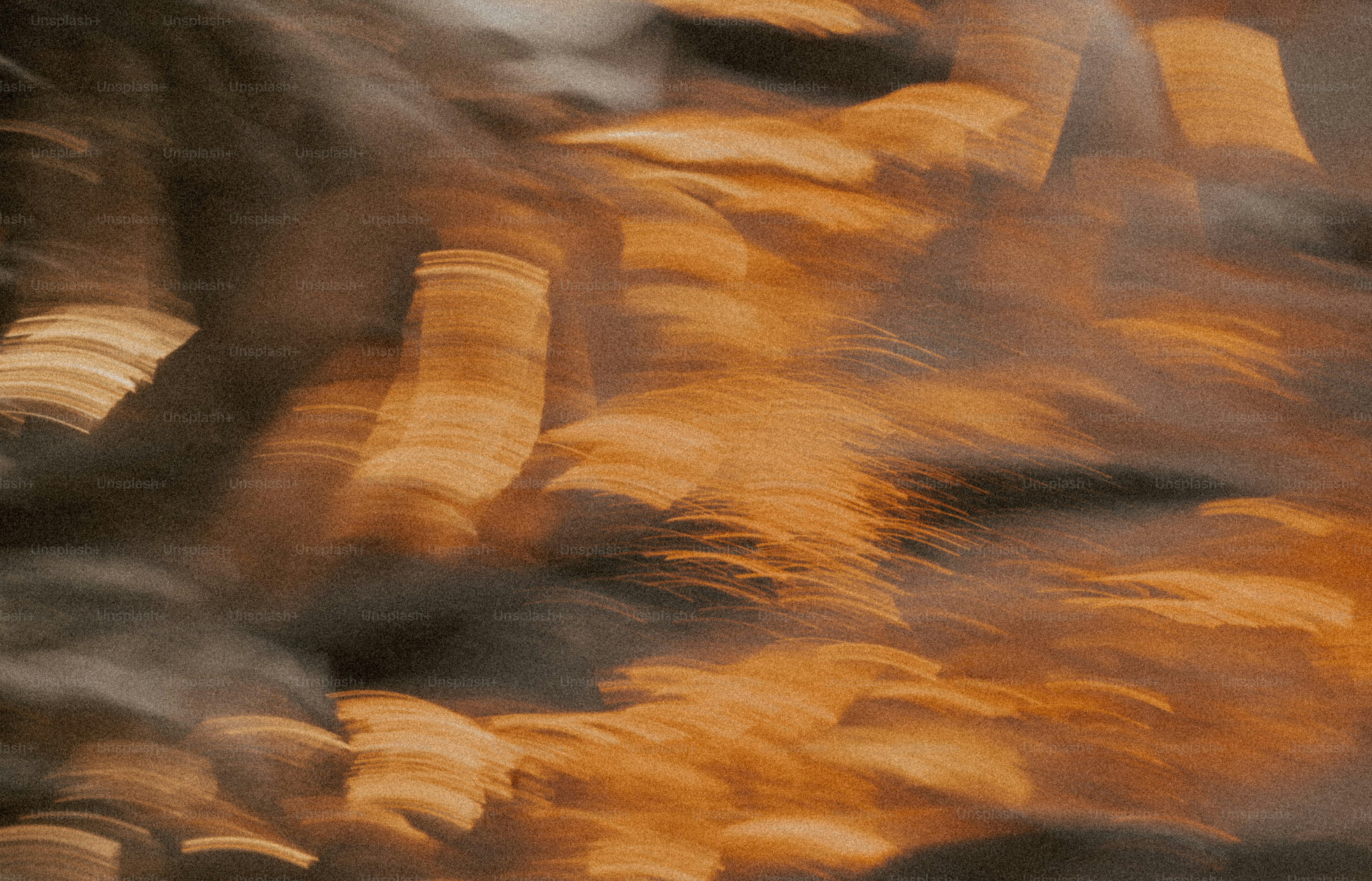 Abstract motion blur of golden light streaks against a dark textured background