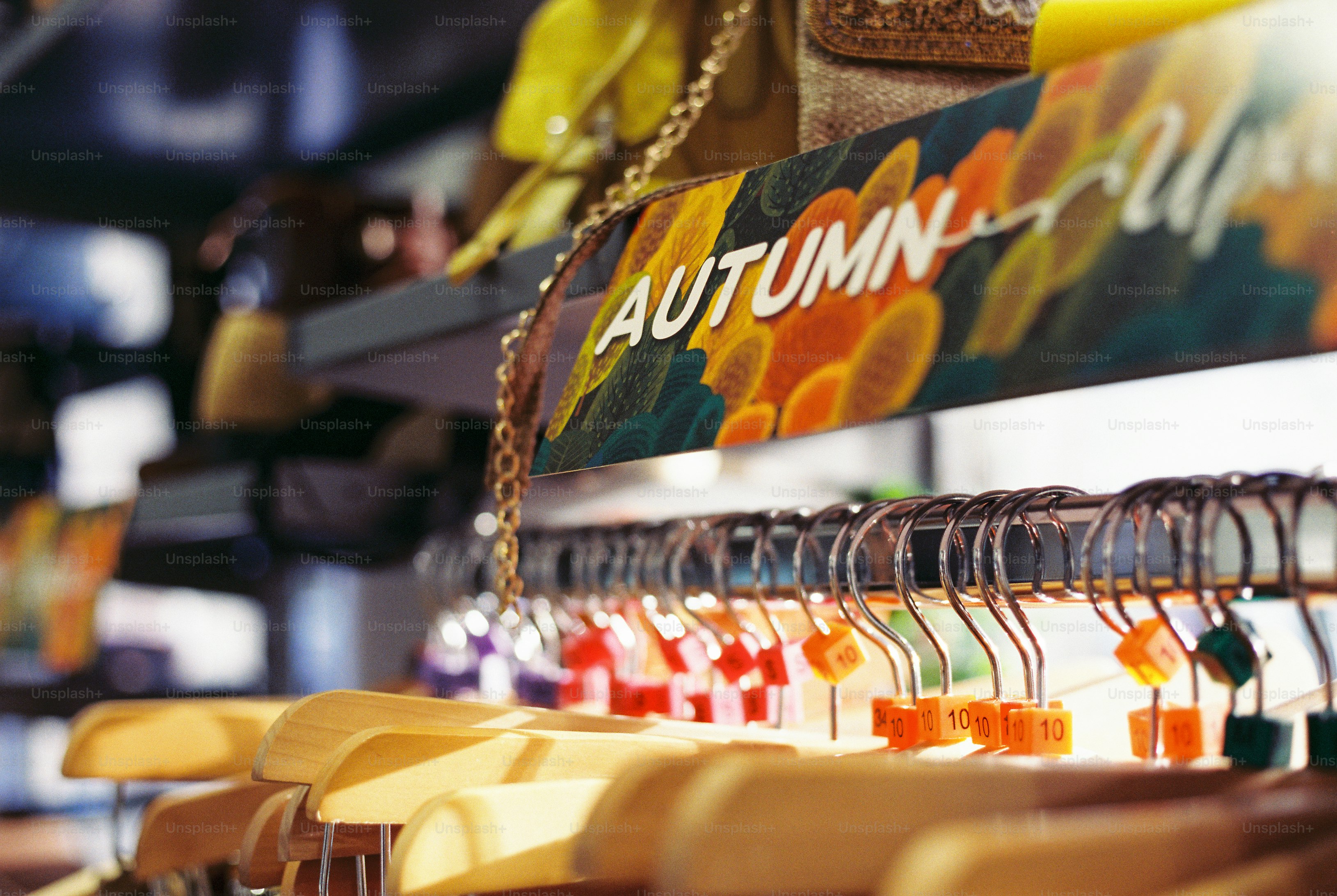 Autumn sign above clothing hangers - Photo on Unsplash+
