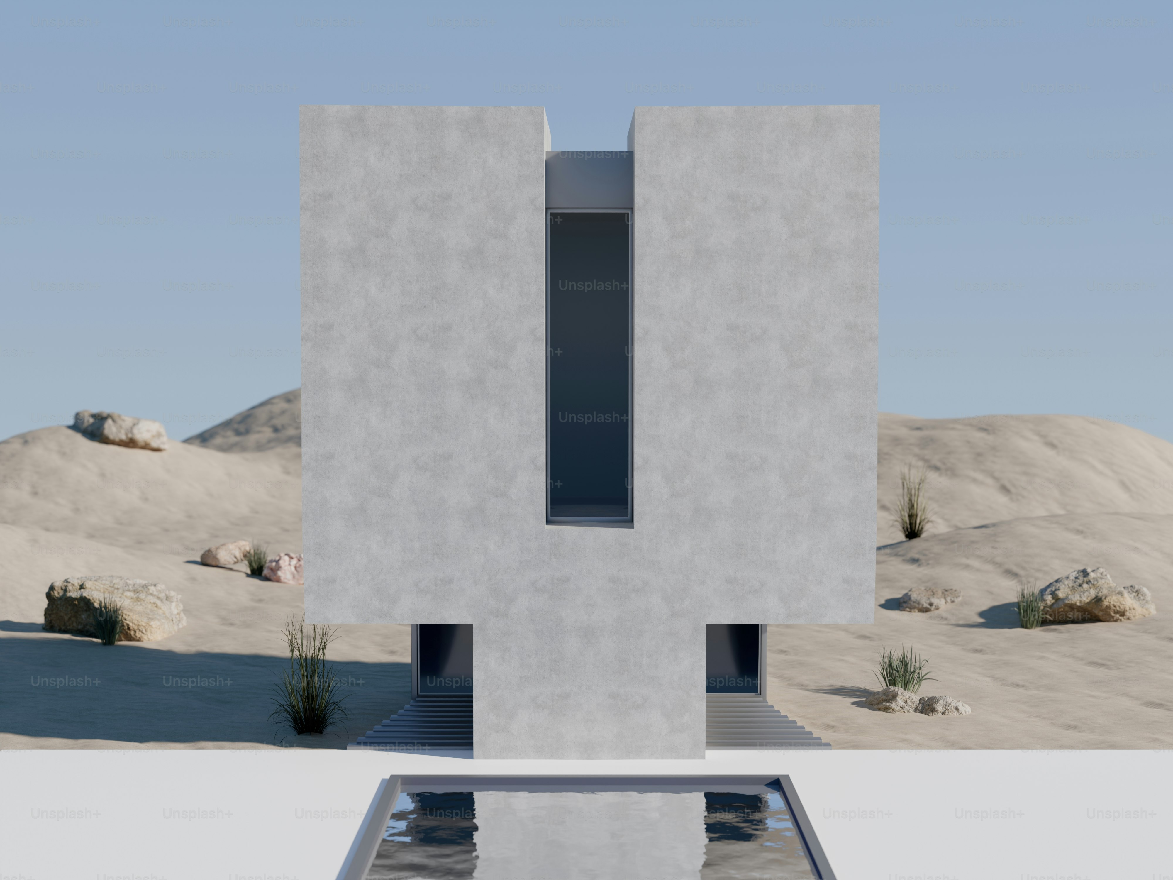 Um edifício moderno de concreto com uma janela vertical central em uma paisagem desértica