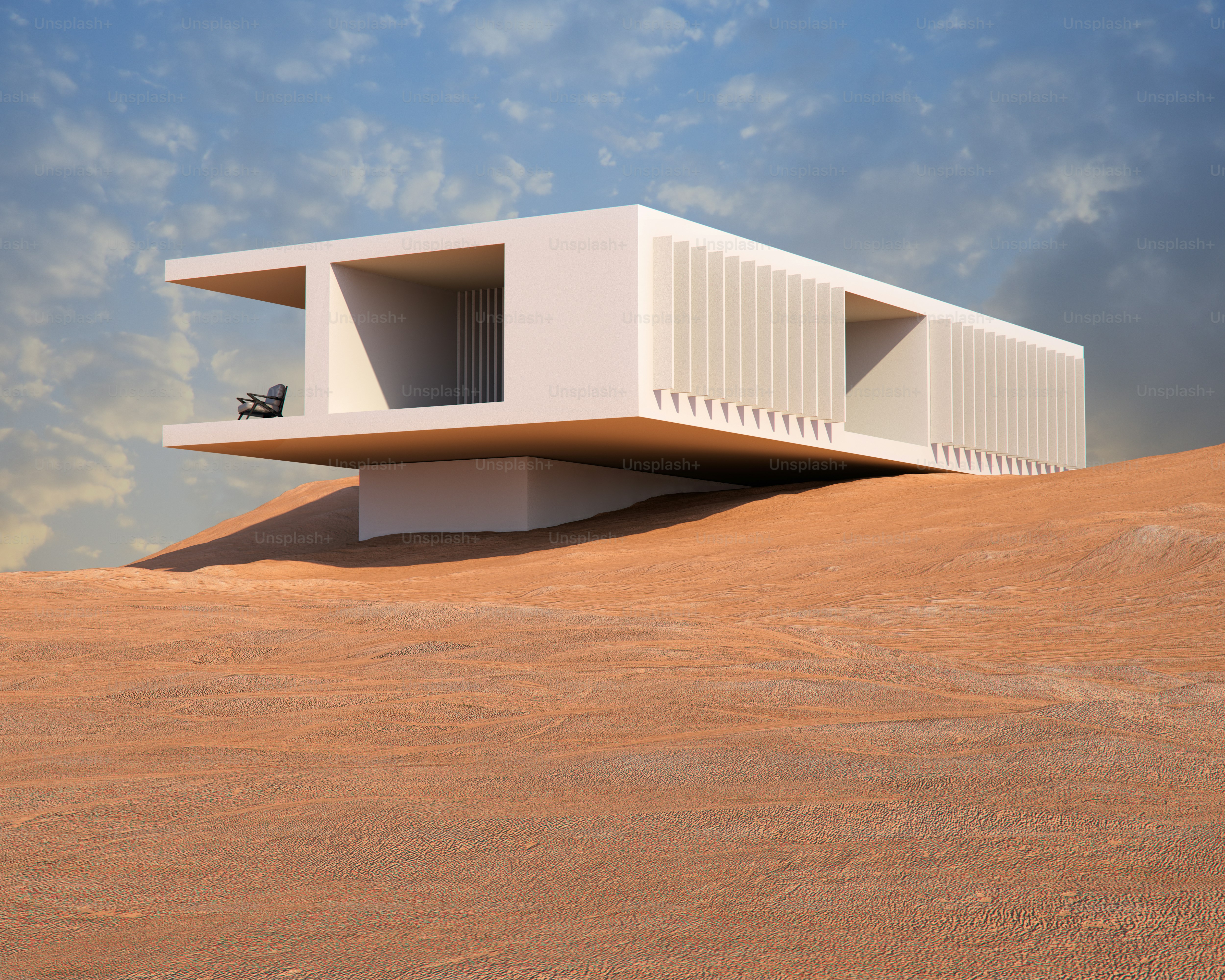 Una casa moderna y blanca con una terraza en voladizo sobre un paisaje desértico arenoso