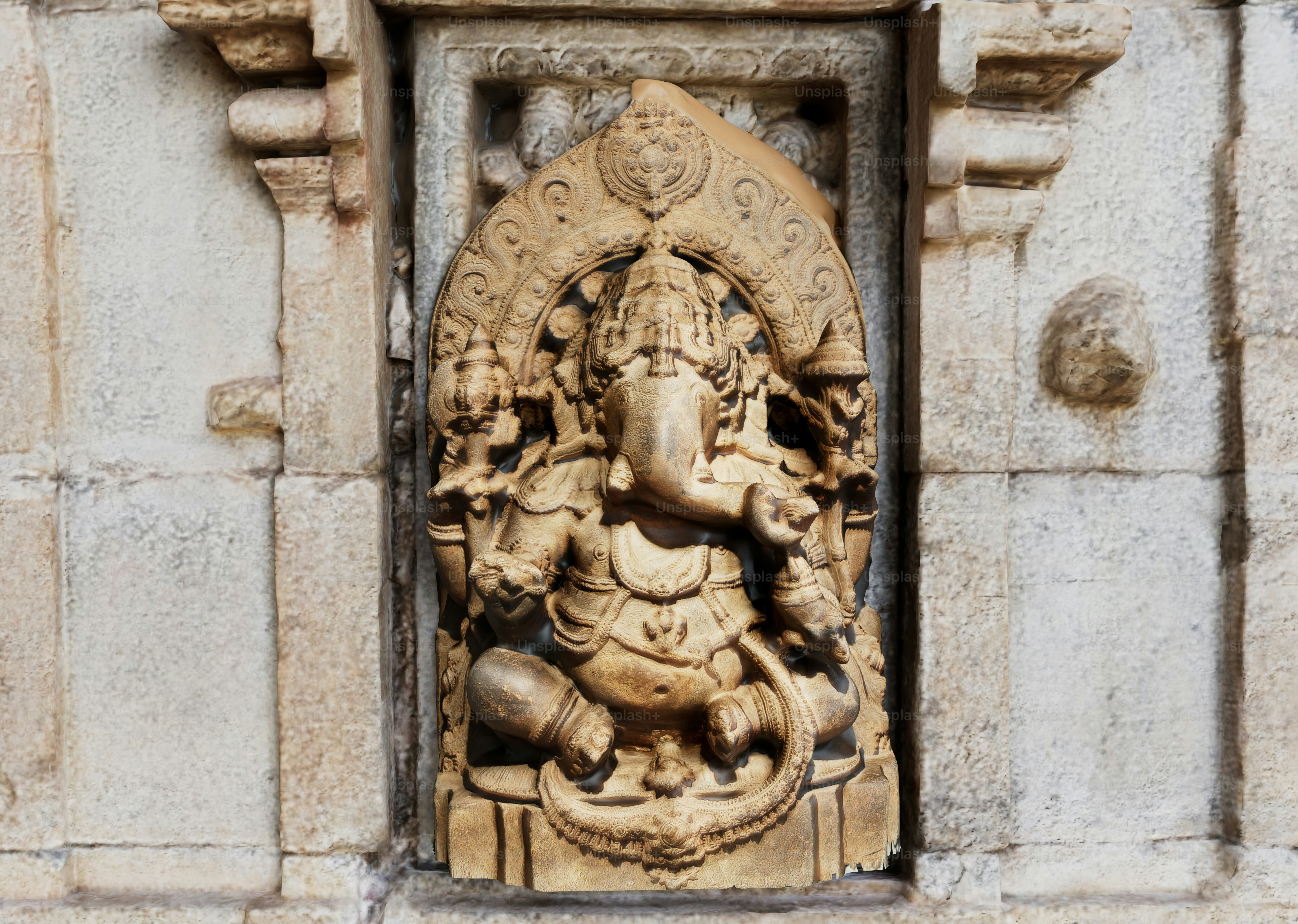 Una talla en piedra de Ganesha incrustada en la pared desgastada de un templo