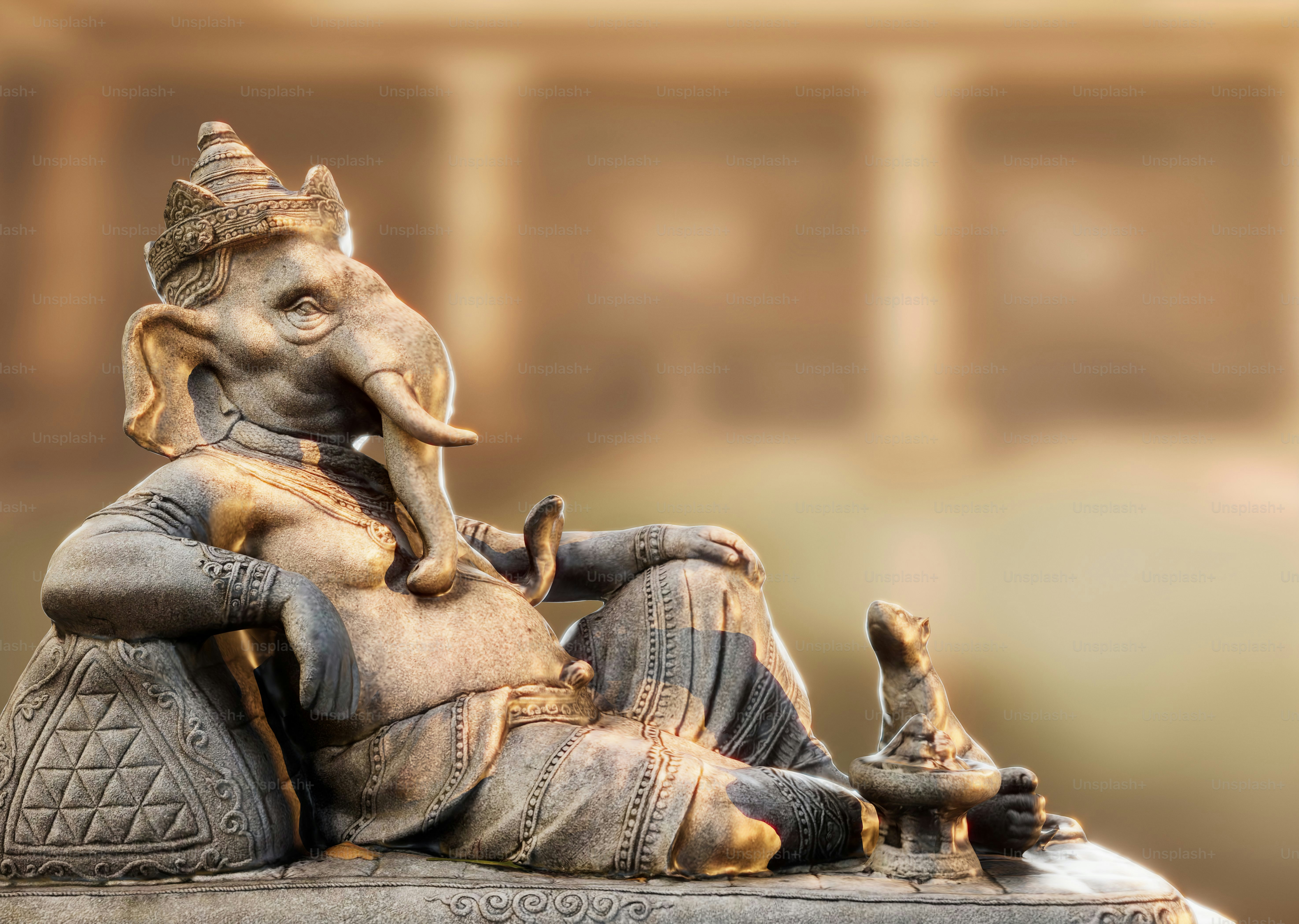 Una estatua de piedra de Ganesha recostado con una pequeña figura de ratón a su lado