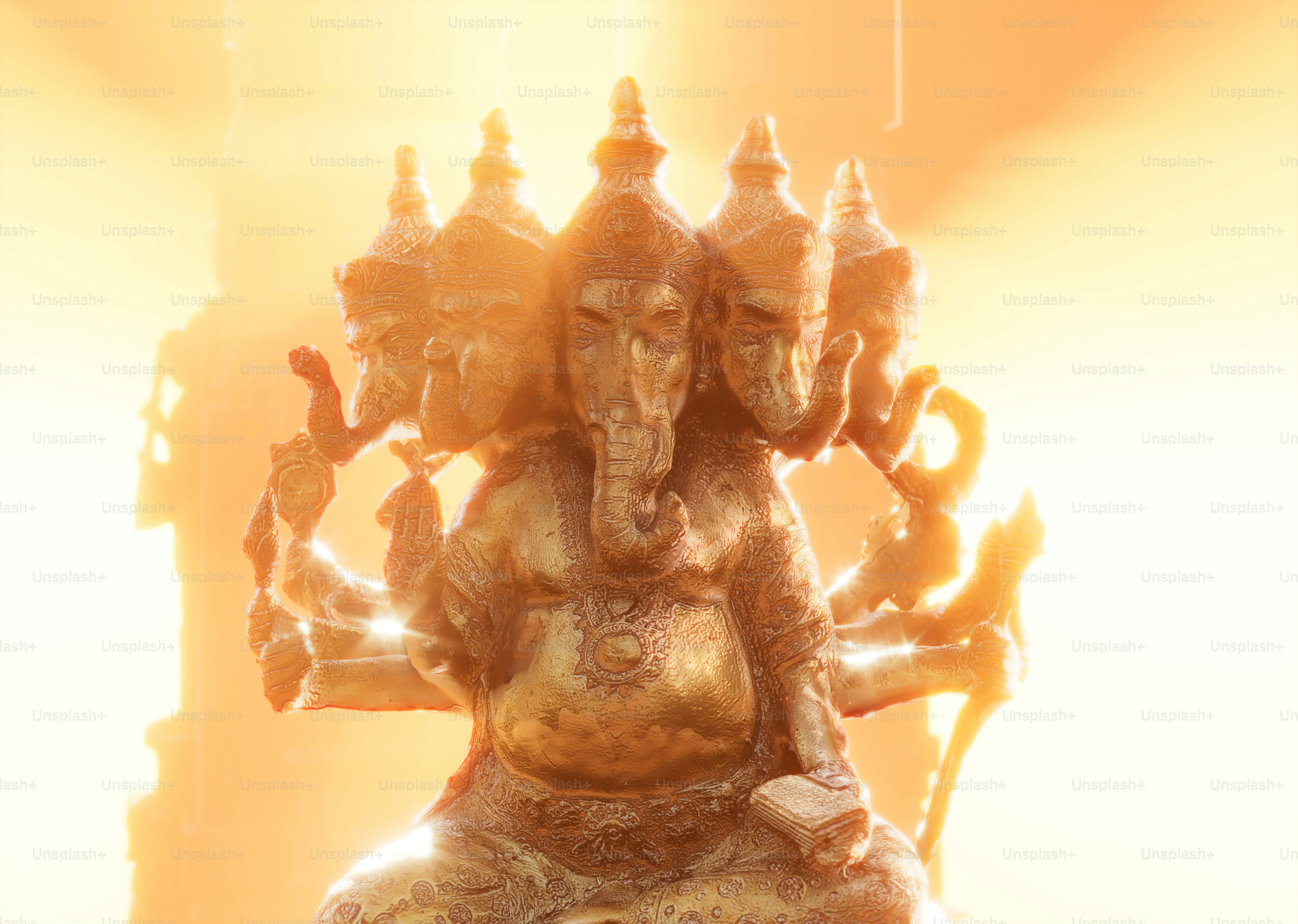 Una estatua dorada de Ganesha con múltiples cabezas y brazos bajo una luz brillante