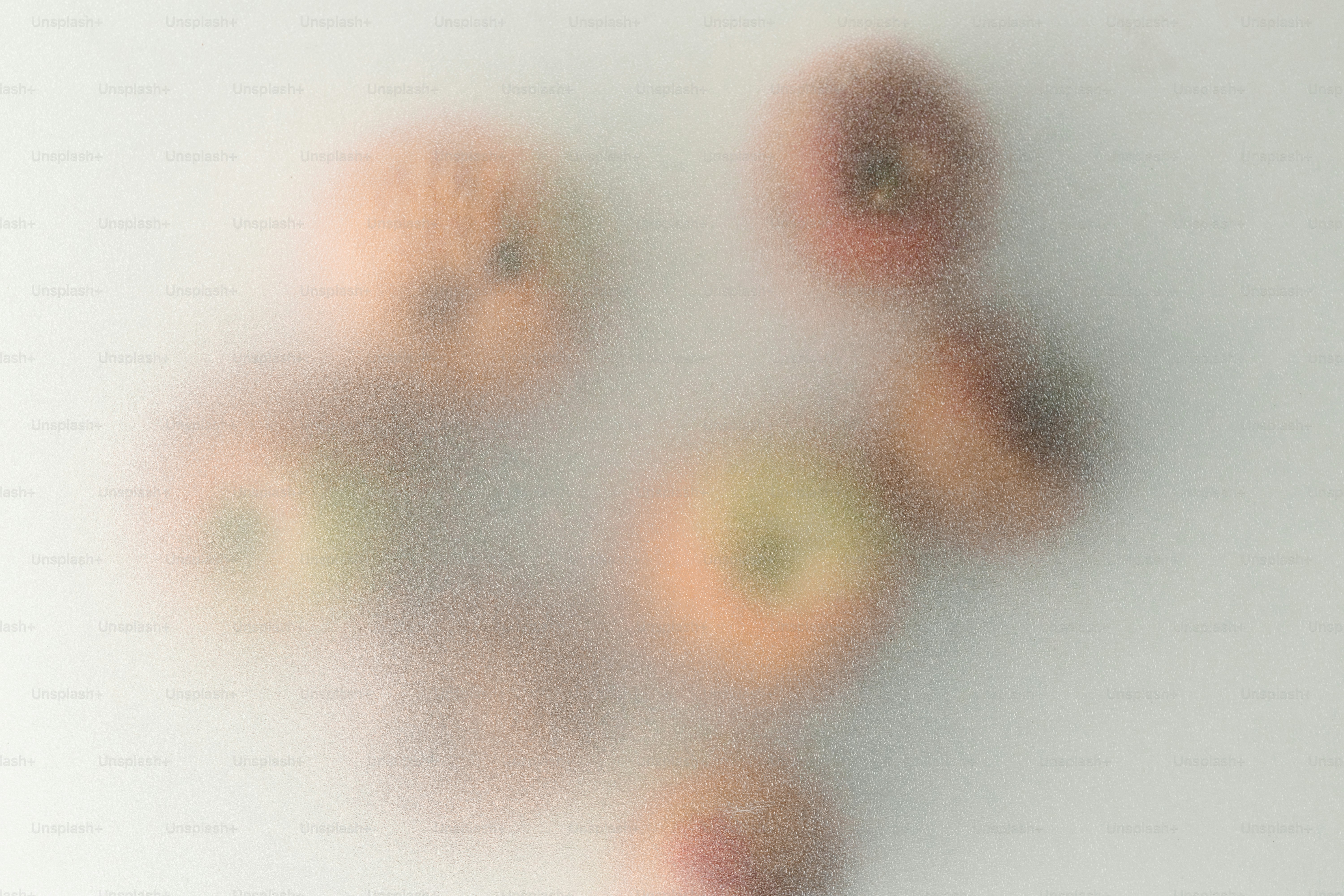 Five apples seen through a frosted glass surface with a soft texture
