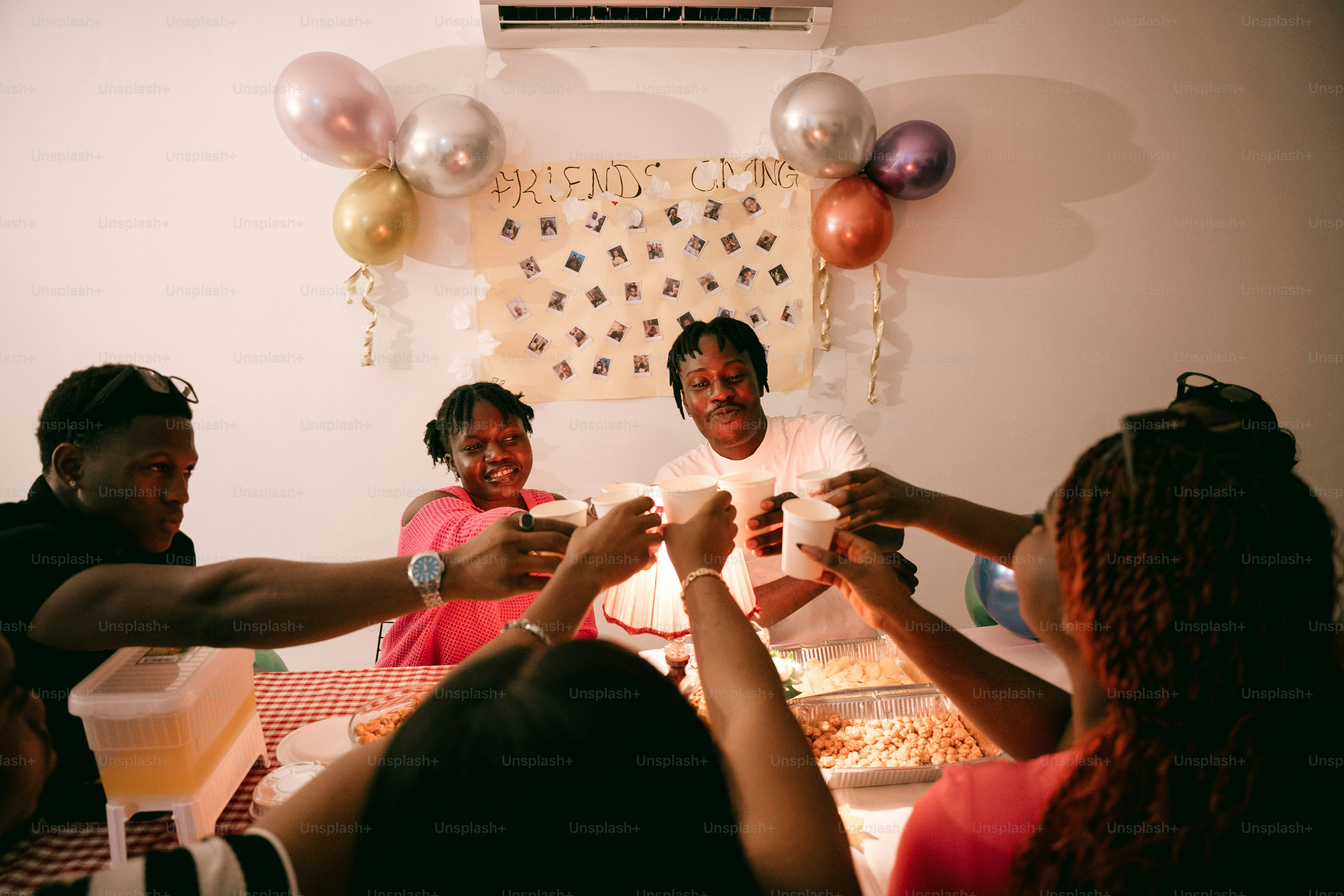 A group of people toasting with white cups at a festive dinner party
