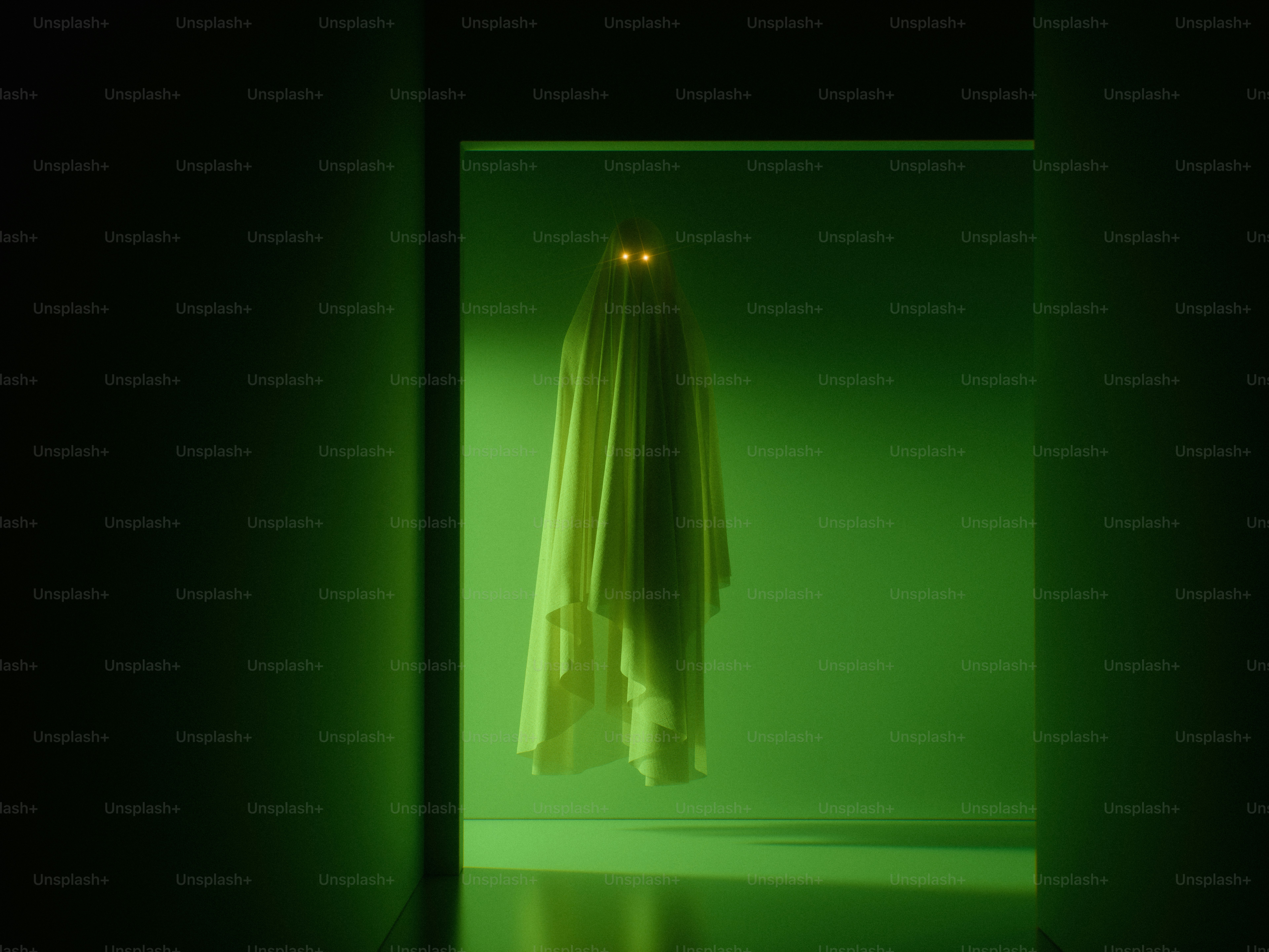 A sheet draped over a form with glowing yellow eyes in a green room
