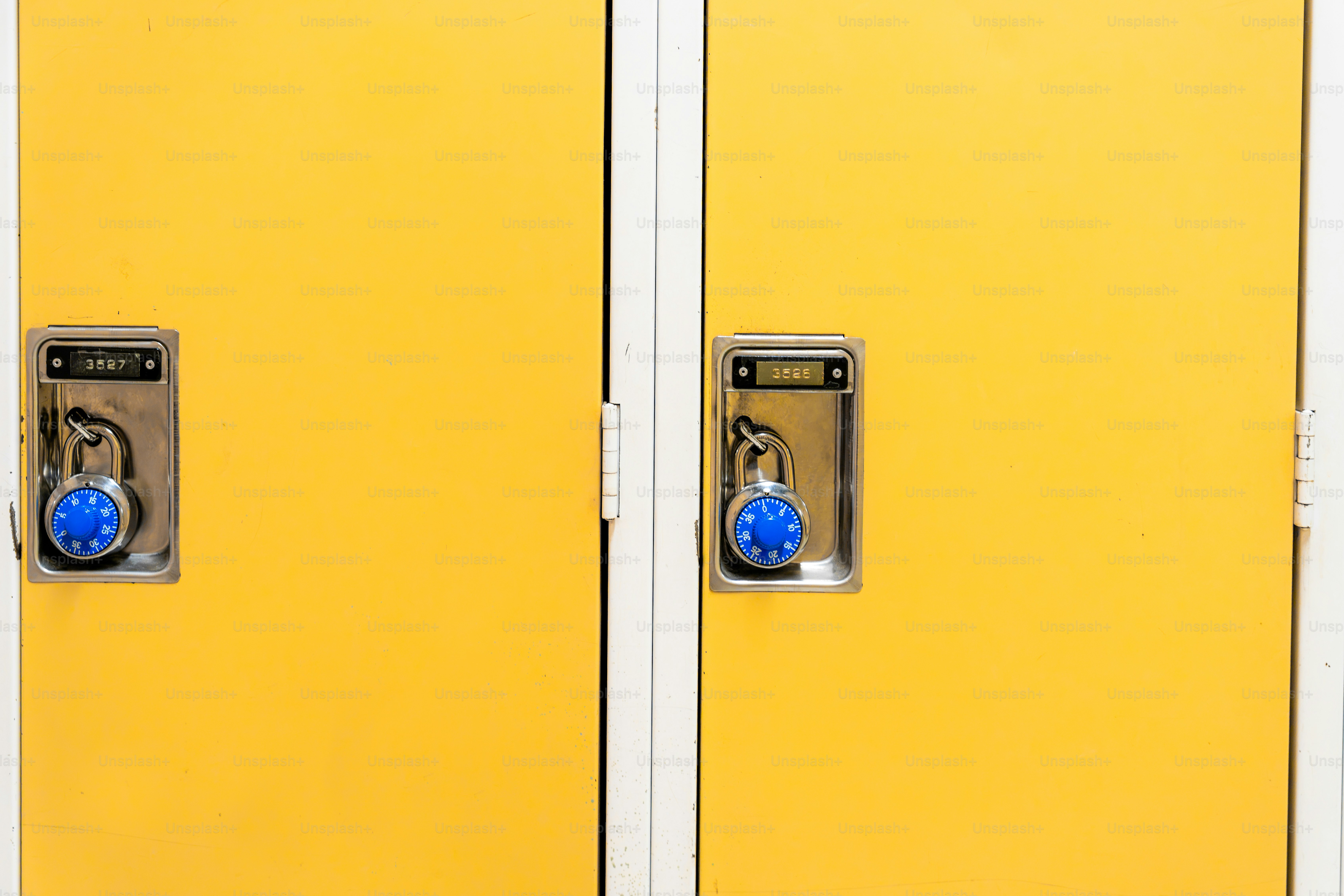 Deux casiers métalliques jaunes sécurisés par des cadenas à combinaison bleu